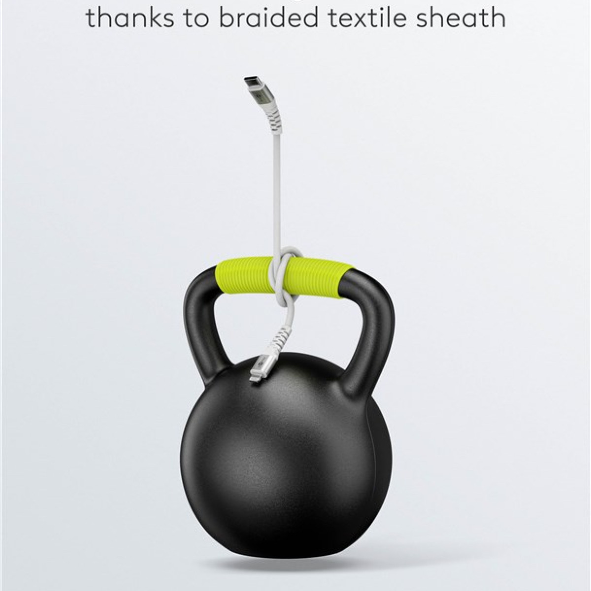 Un cavo di ricarica bianco appeso a un kettlebell nero tramite la sua guaina tessile intrecciata.