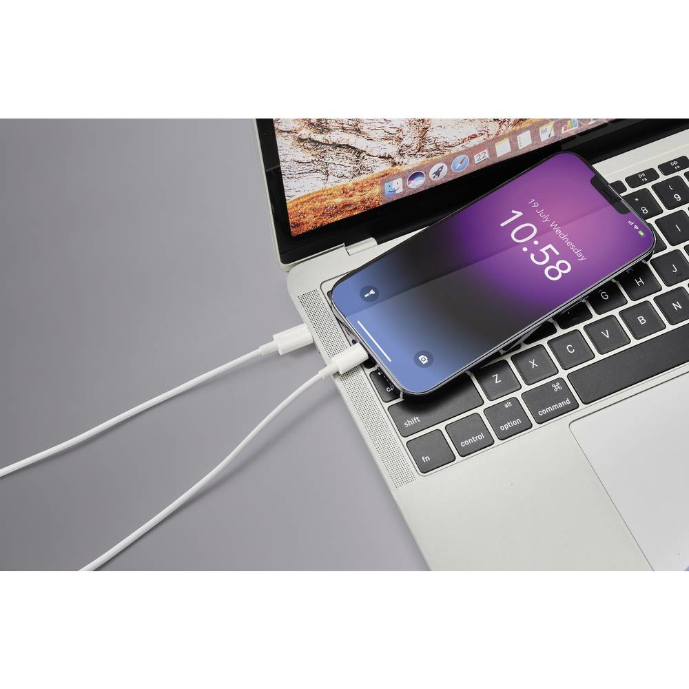 Laptop che carica telefono con cavo bianco. Telefono mostra 10:58.