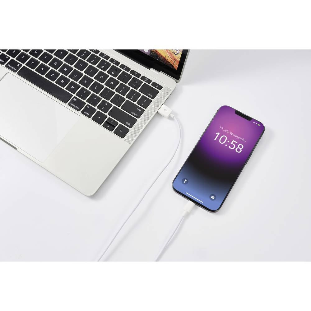 Laptop z telefonem ładującym się białym kablem. Telefon pokazuje 10:58.