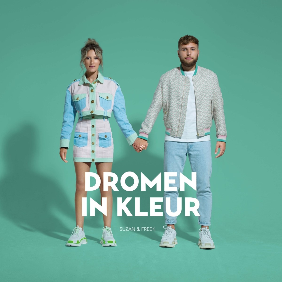 Koppel hand in hand, voor een groene achtergrond. Titel: 'Dromen in Kleur' van Suzan & Freek.