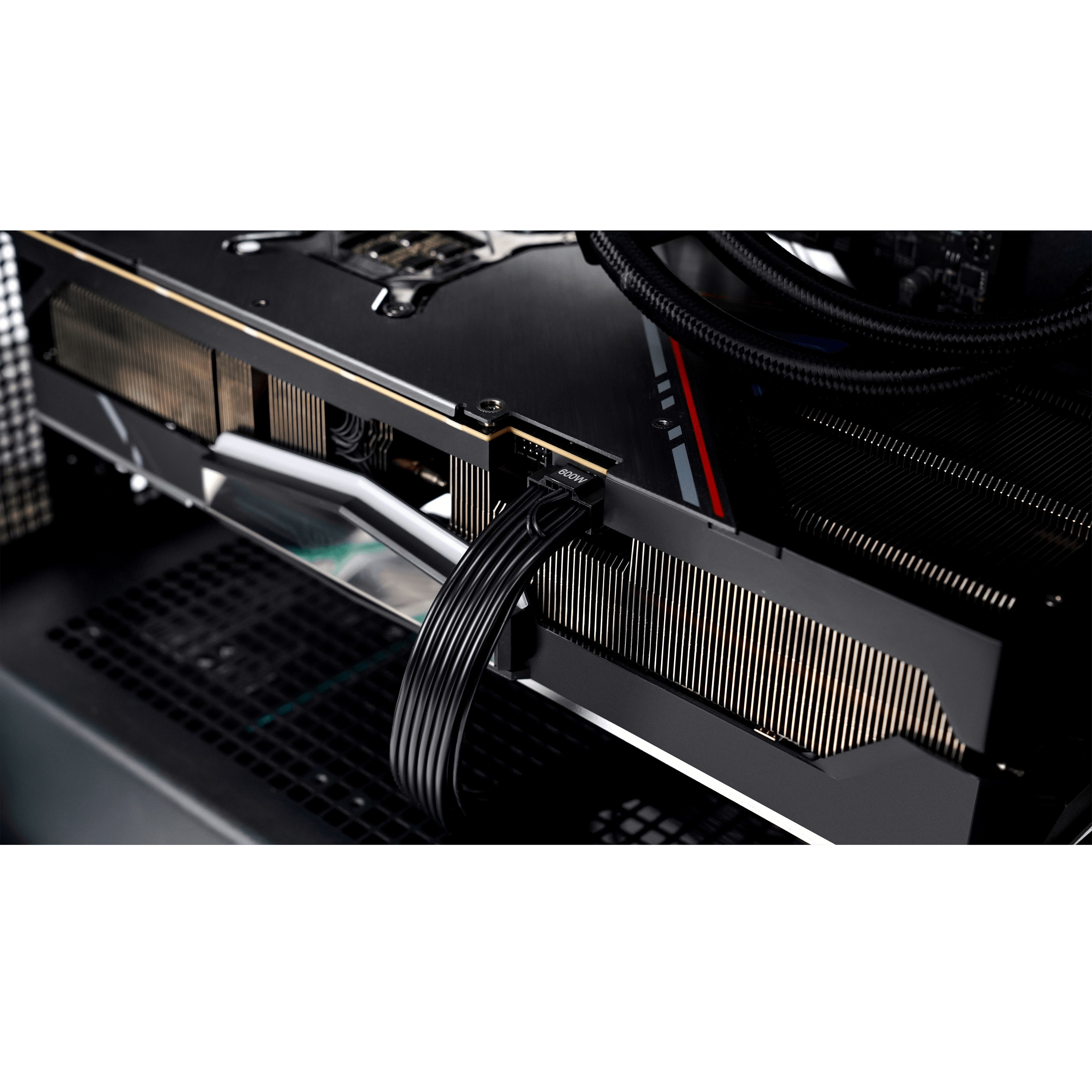 Karta graficzna PC z podłączonymi czarnymi kablami zasilającymi, wewnątrz obudowy komputera.