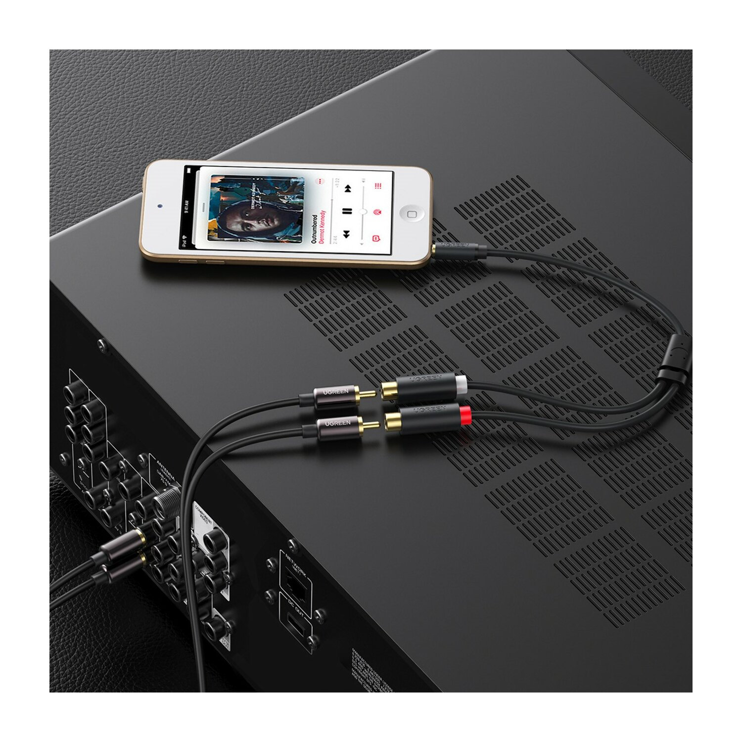 iPod podłączony do systemu stereo za pomocą kabli audio; widoczne złącza RCA i 3,5 mm.