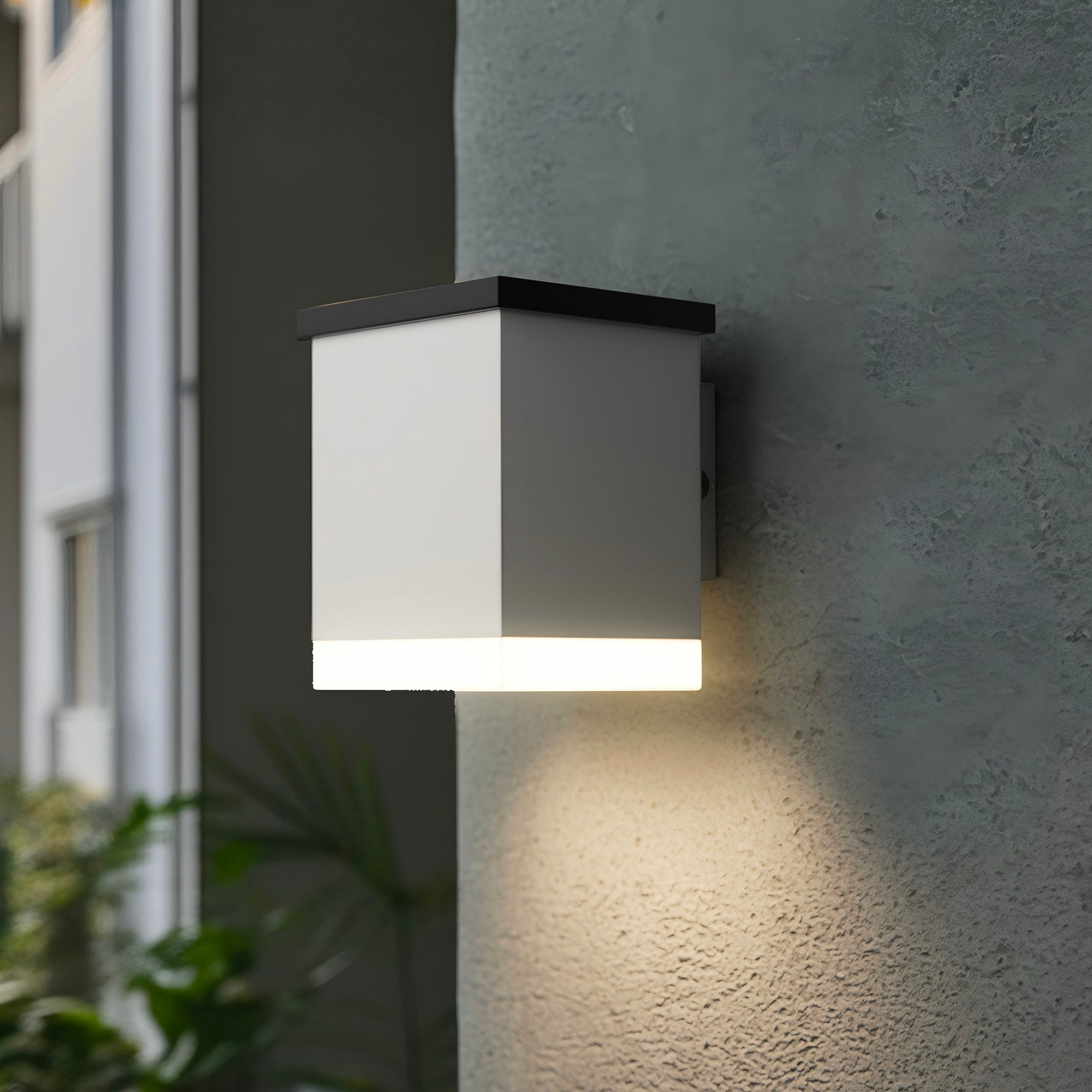 Weiße und schwarze Außenwandleuchte, beleuchtet. An einer strukturierten Wand montiert.