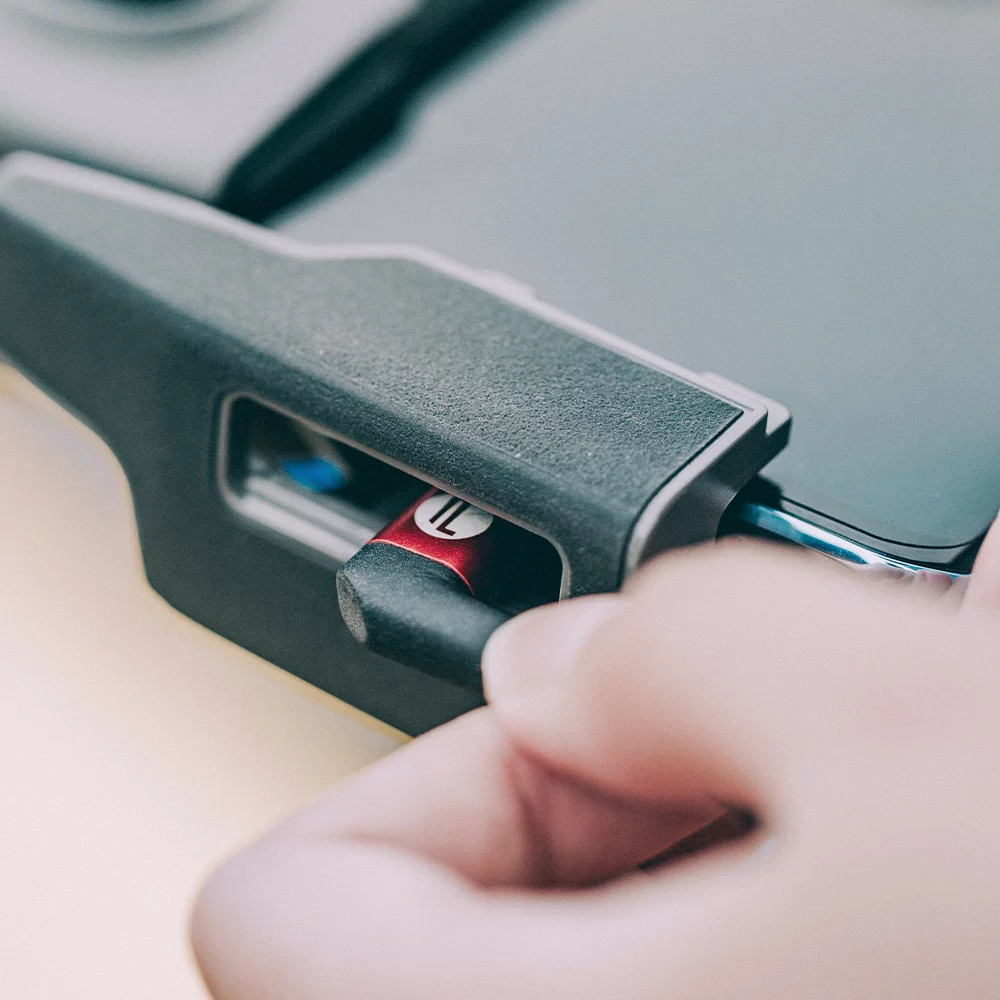 Zbliżenie czerwono-czarnego kabla ładującego wkładanego do urządzenia.