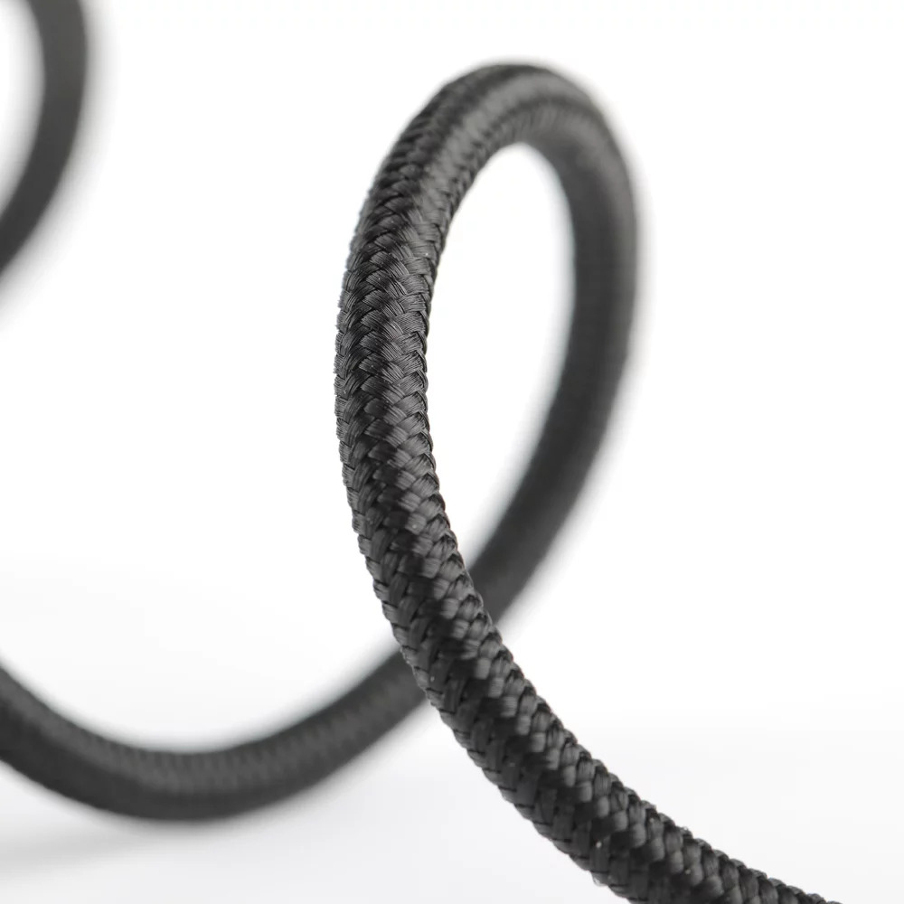 Czarny pleciony kabel zwinięty na białym tle.