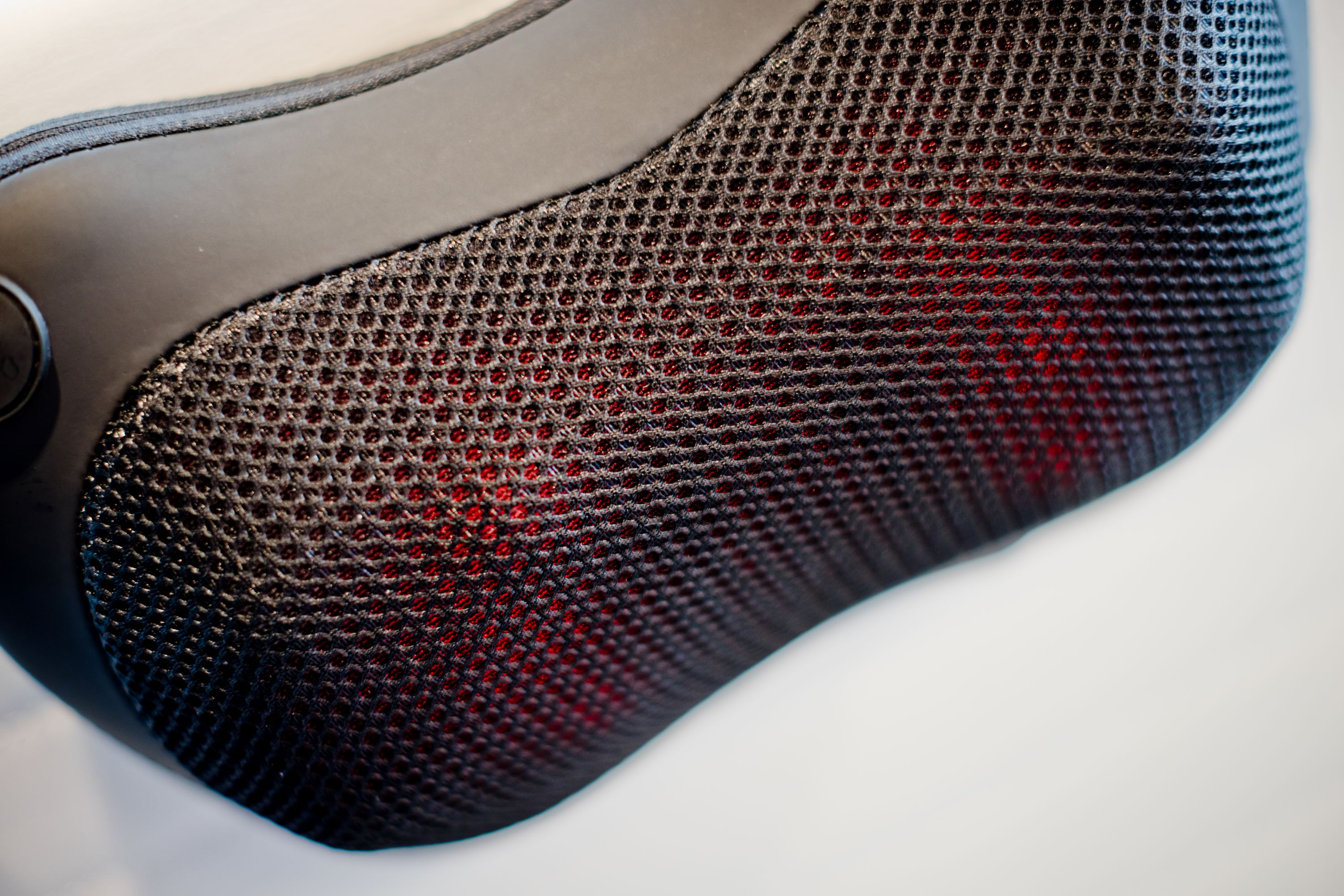 Close up of a massage pillow. The pillow has a mesh section with red lights visible.