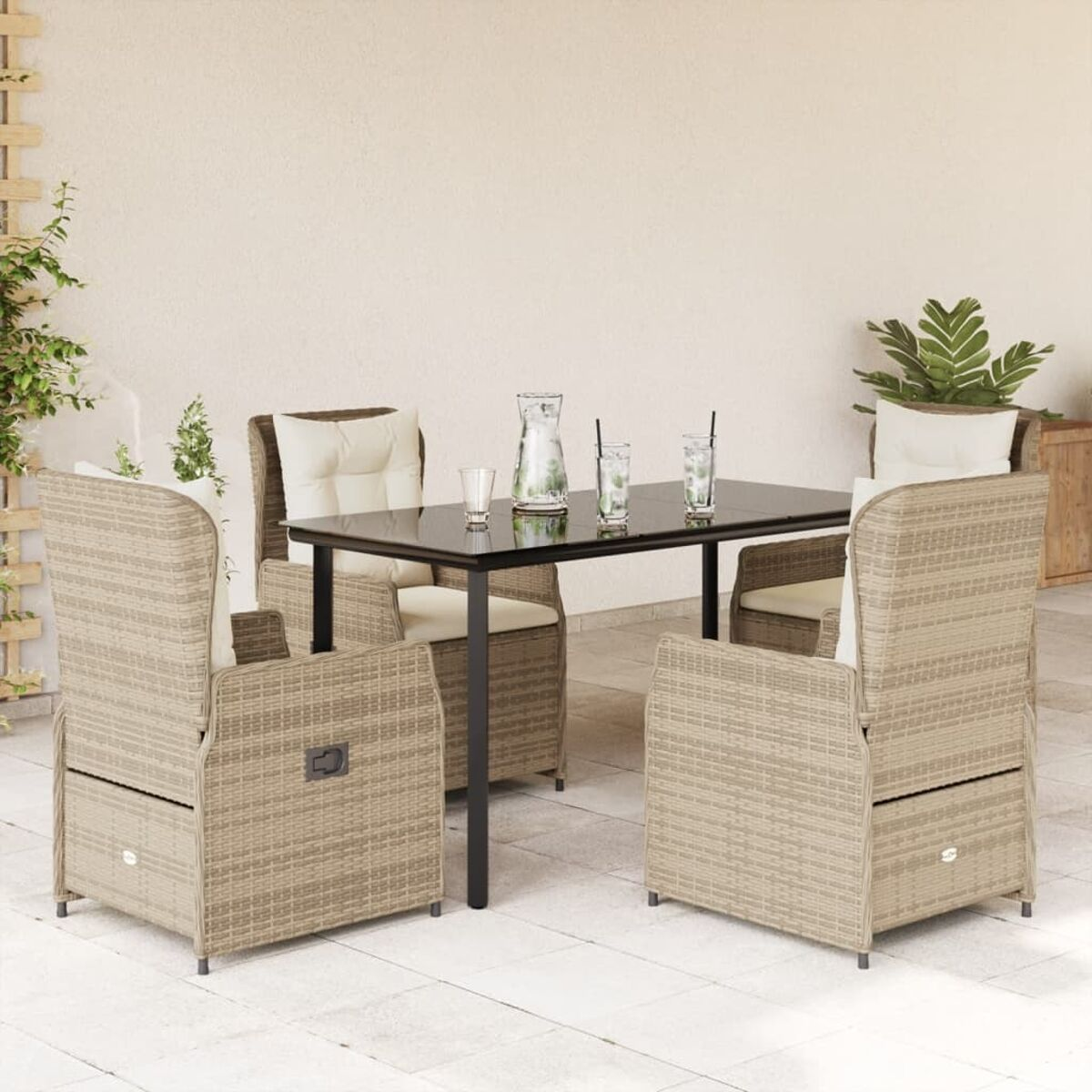 Ein Terrassenset mit einem schwarzen Tisch, vier Stühlen und Pflanzen im Hintergrund.