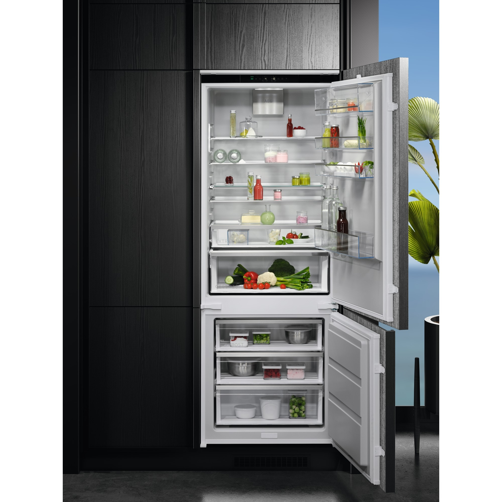 Refrigerador con puertas abiertas, lleno de comida. Armario negro a la izquierda.