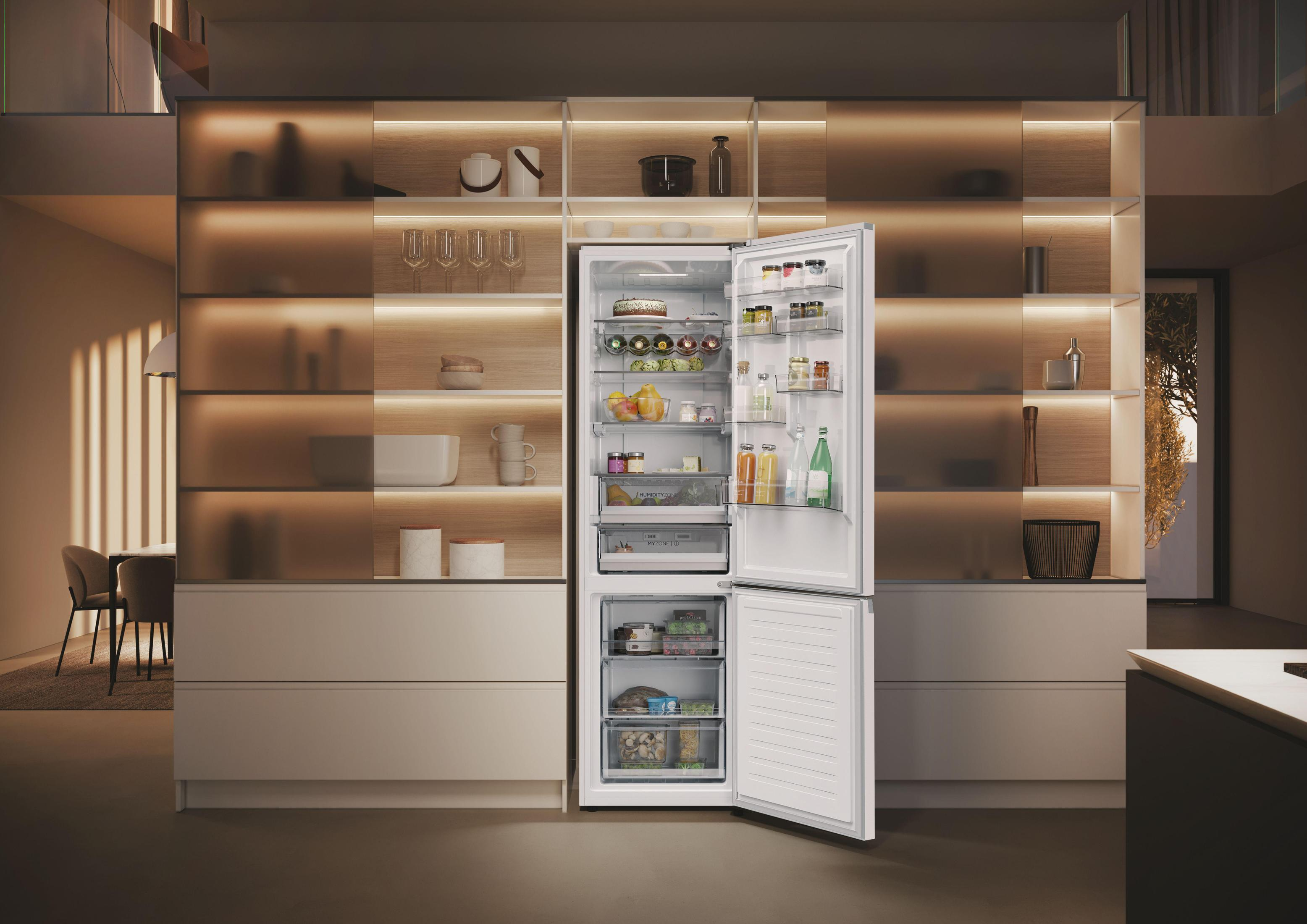 Refrigerador blanco abierto en un entorno de cocina moderno con elementos dentro.