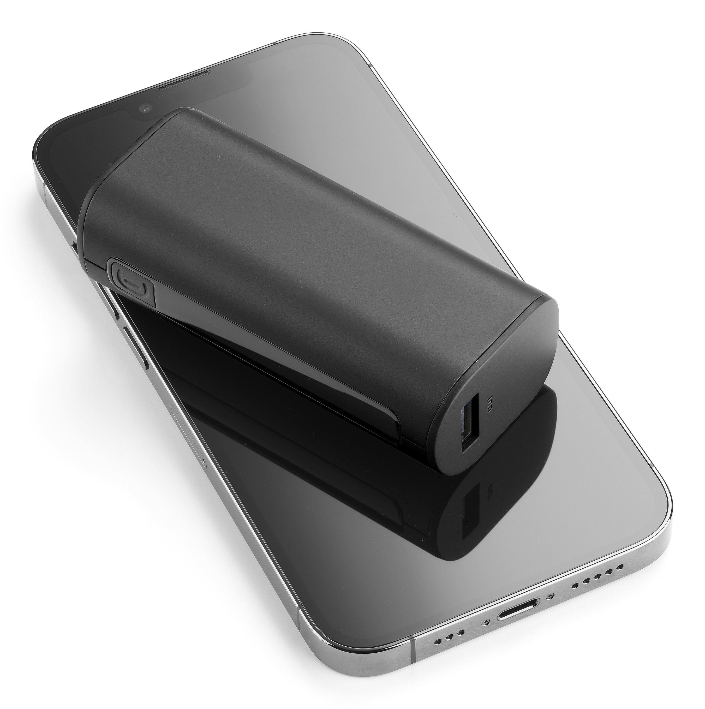 Schwarze Powerbank liegt auf einem schwarzen Smartphone, schräge Ansicht.