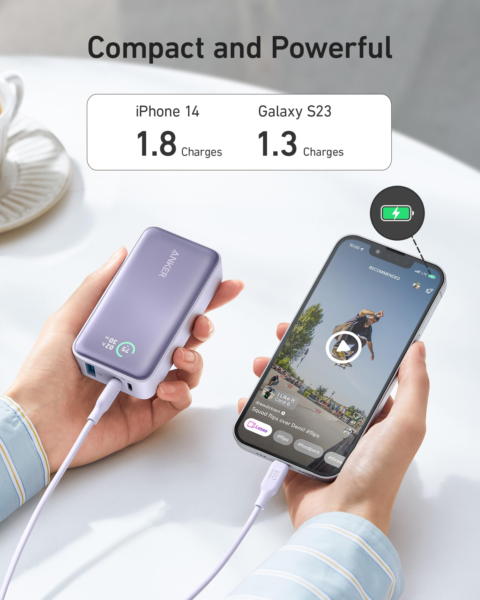 Mano che tiene un power bank che carica un telefono. Il telefono mostra un video. Testo: Compatto e potente.