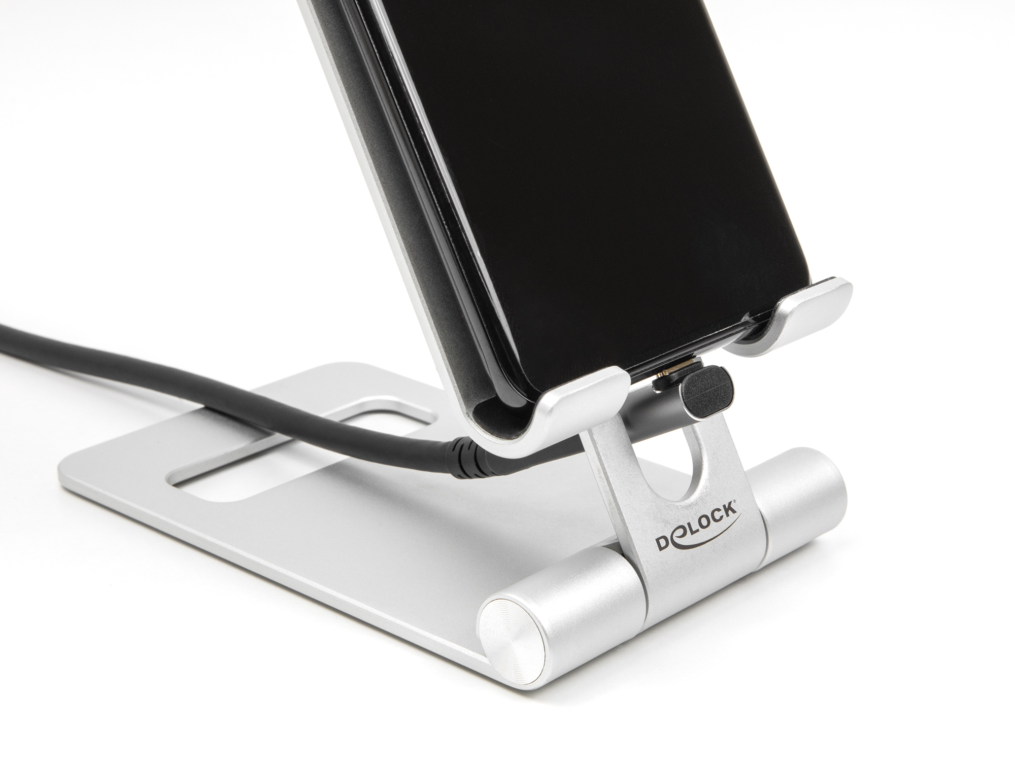Supporto telefono argento che tiene un telefono nero su sfondo bianco. Cavo nero collegato.