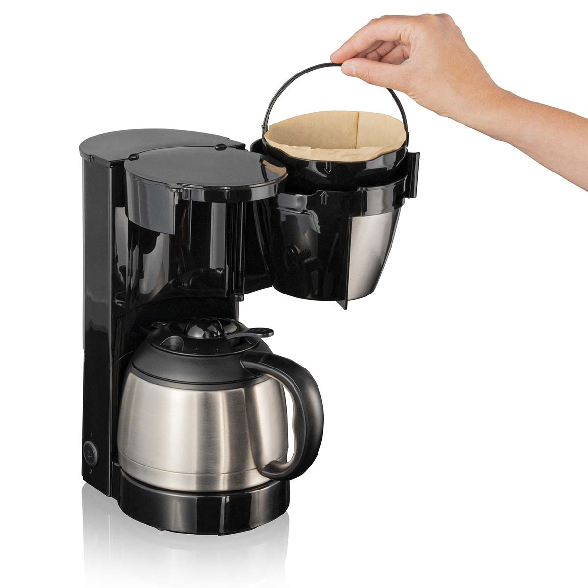 Macchina da caffè nera con caraffa argentata. Una mano tiene il cestello del filtro.