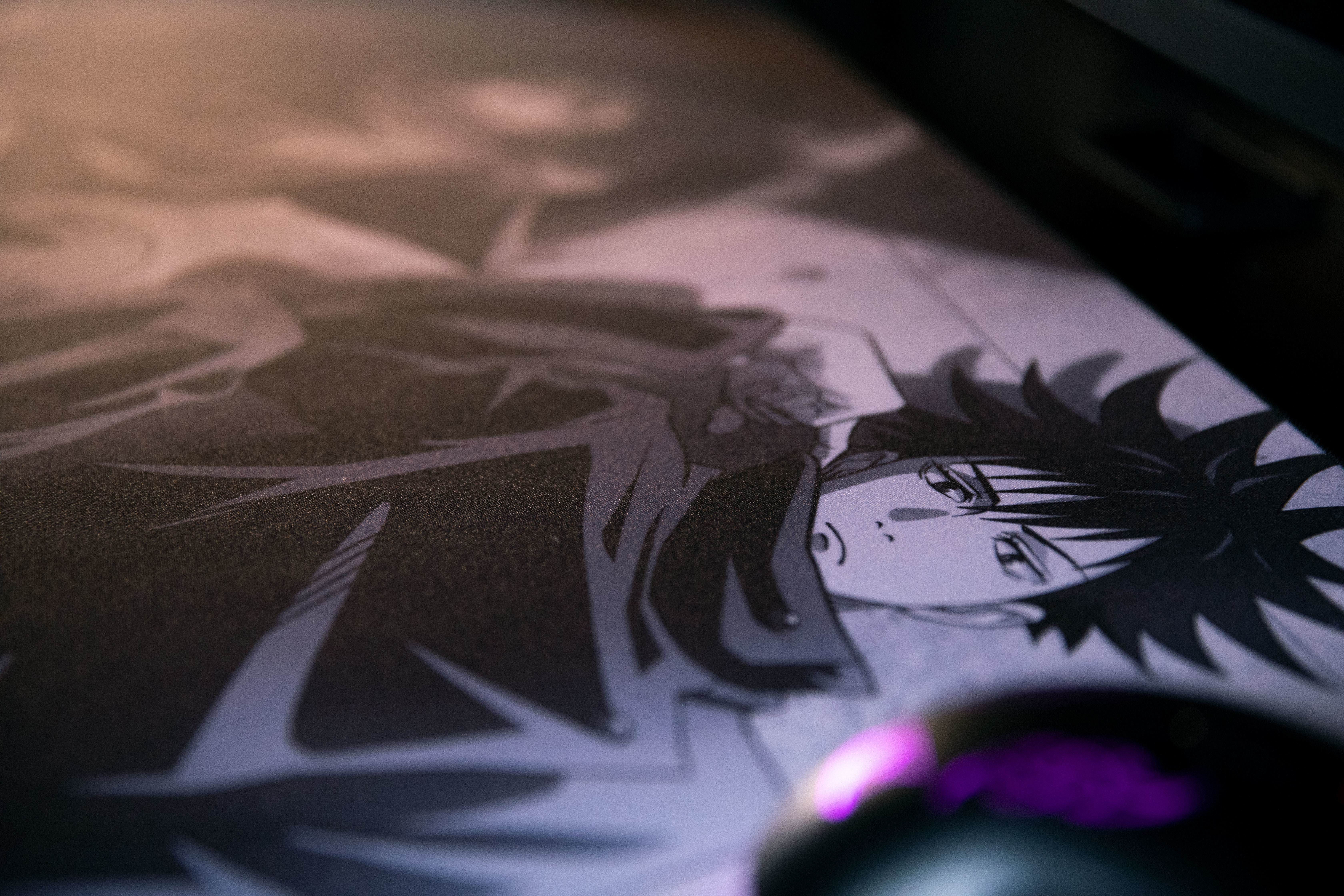 Podkładka pod mysz z motywem anime. Widoczna twarz postaci. Myszka jest na pierwszym planie.