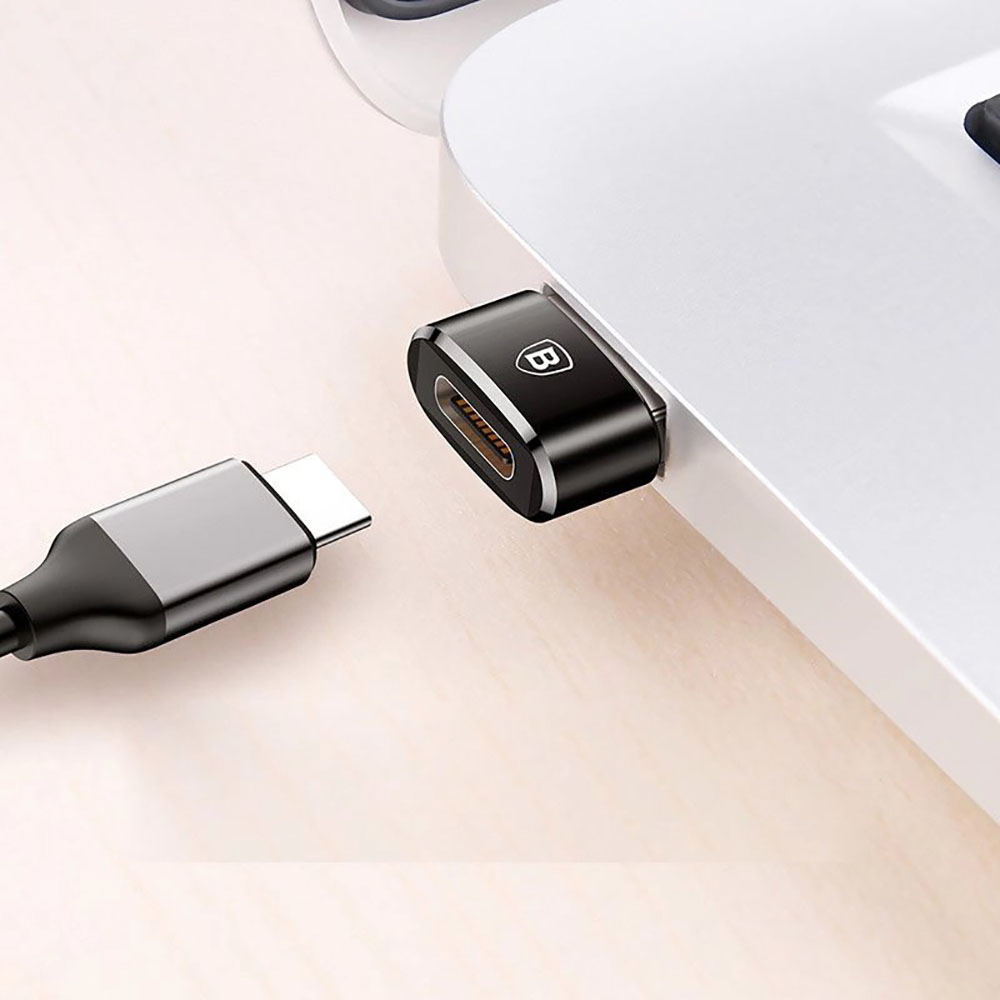 Czarny adapter podłączony do laptopa. Kabel USB-C po lewej stronie.