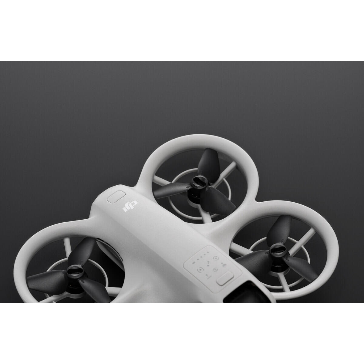 Dron blanco y gris con tres hélices. El dron está contra un fondo gris oscuro.