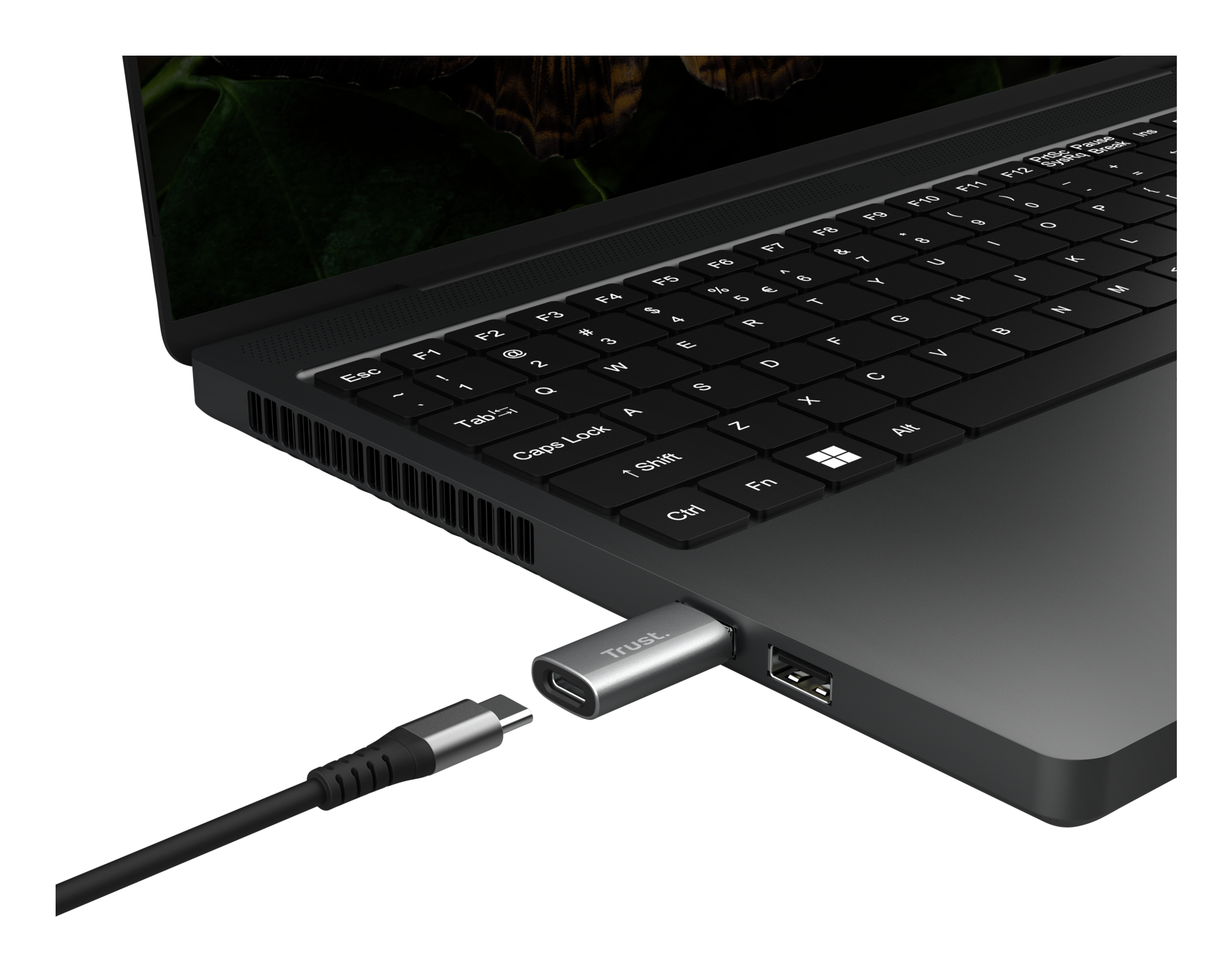 Laptop z włożonym adapterem USB-C. Marka Trust jest widoczna.