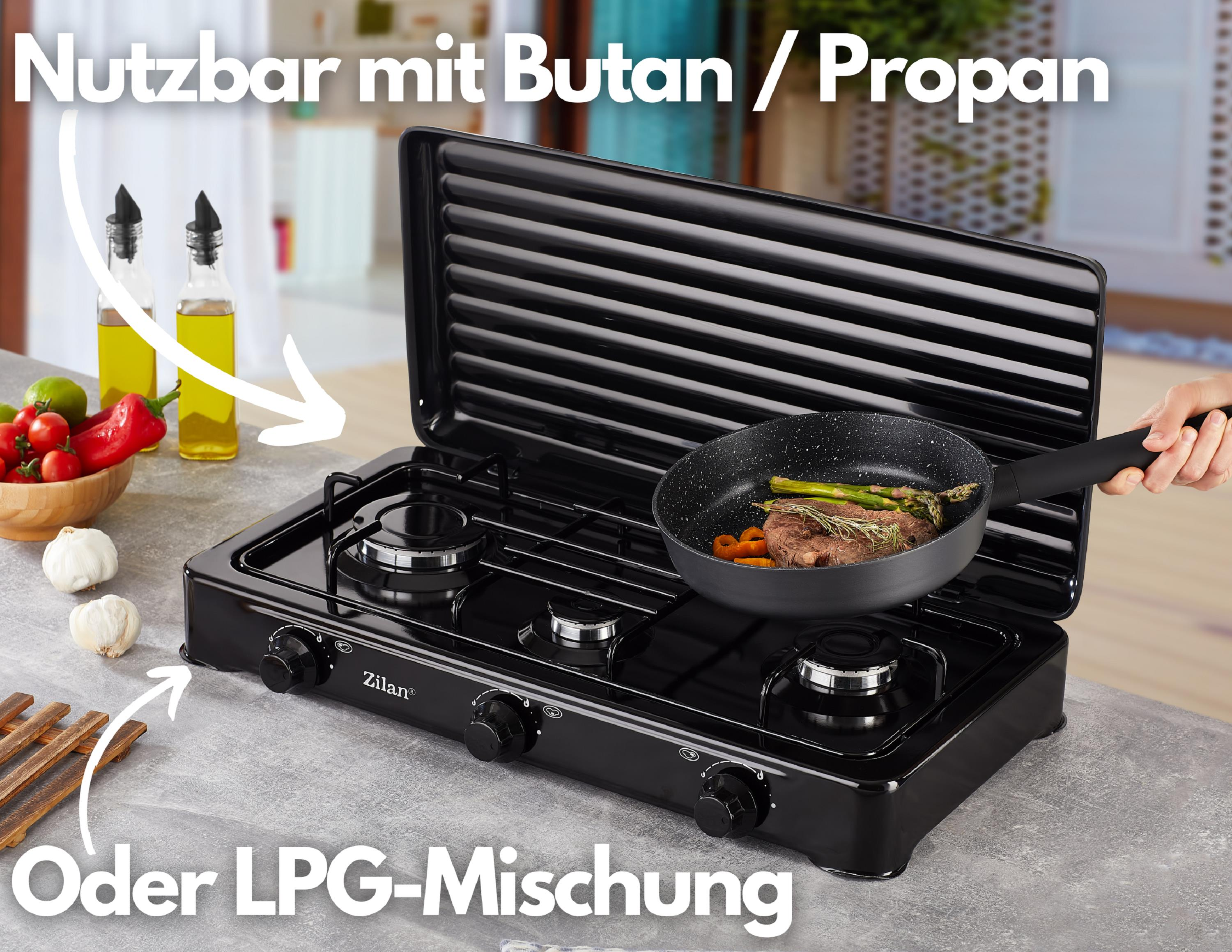 Czarna kuchenka gazowa z jedzeniem. Tekst w wielu językach. Otoczenie kuchni.