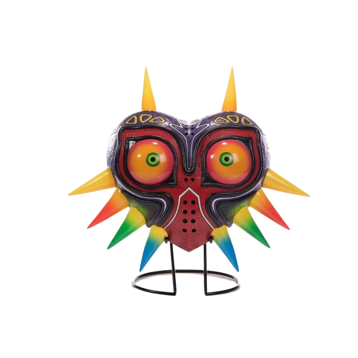 Eine Nachbildung der Majora's Mask auf einem Ständer. Die Maske ist rot, gelb und lila. Schwarzer Hintergrund.