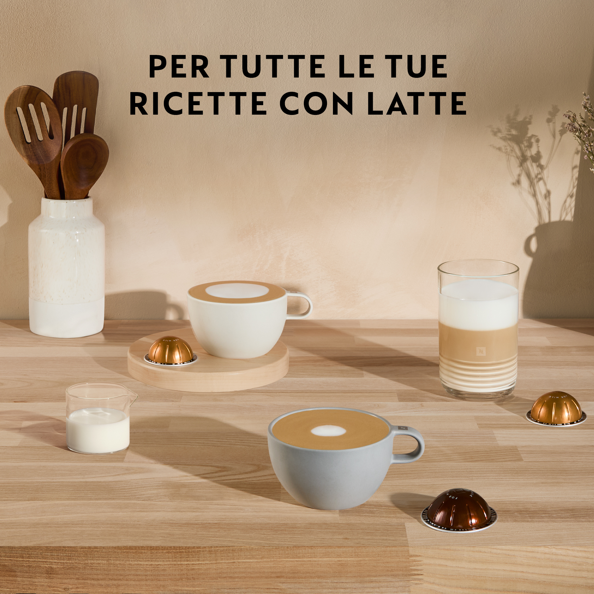 Tazze di caffè e capsule disposte su una superficie di legno.