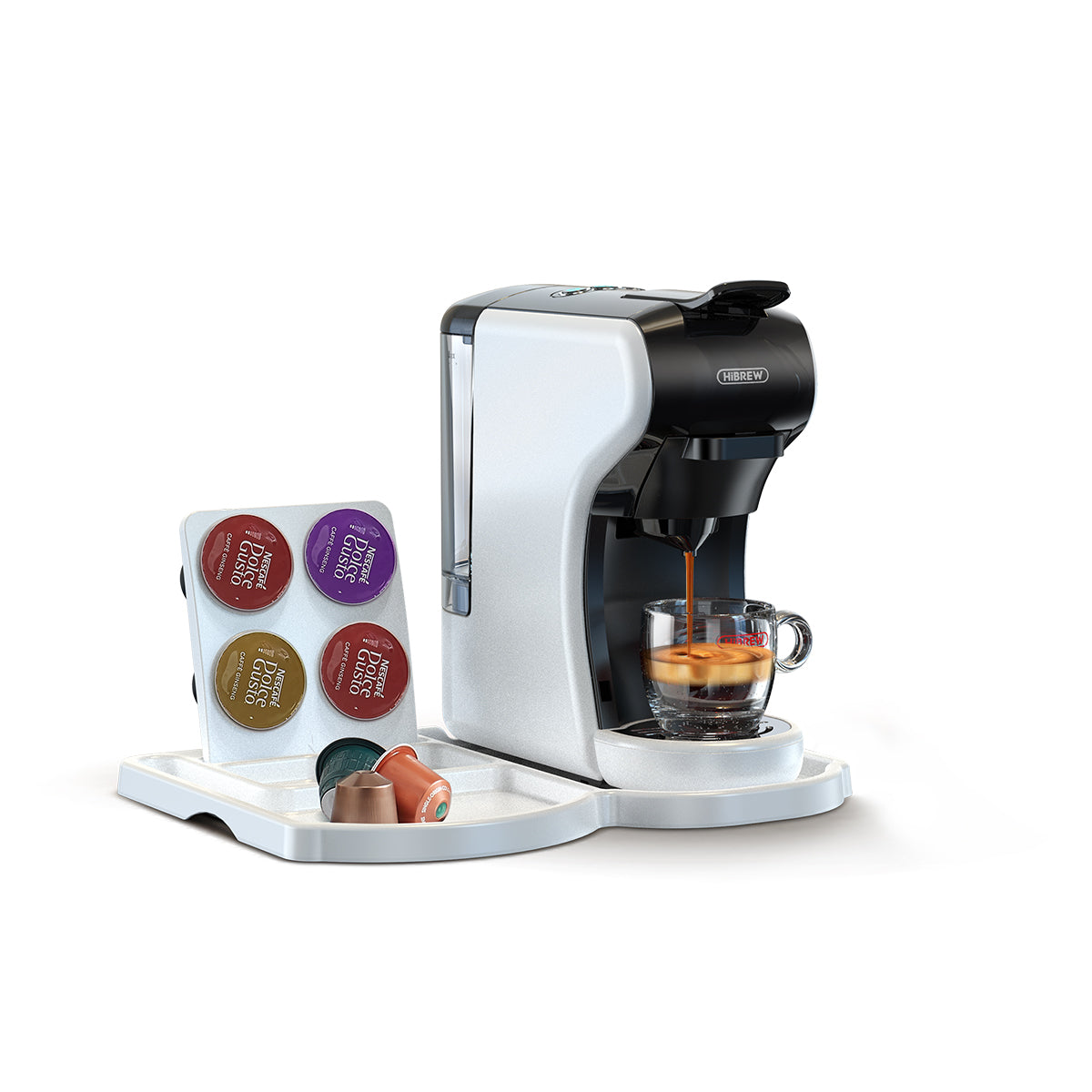Eine weiß-schwarze Kaffeemaschine, die Kaffee in eine Glastasse ausgibt. Kapseln sind an der Seite.