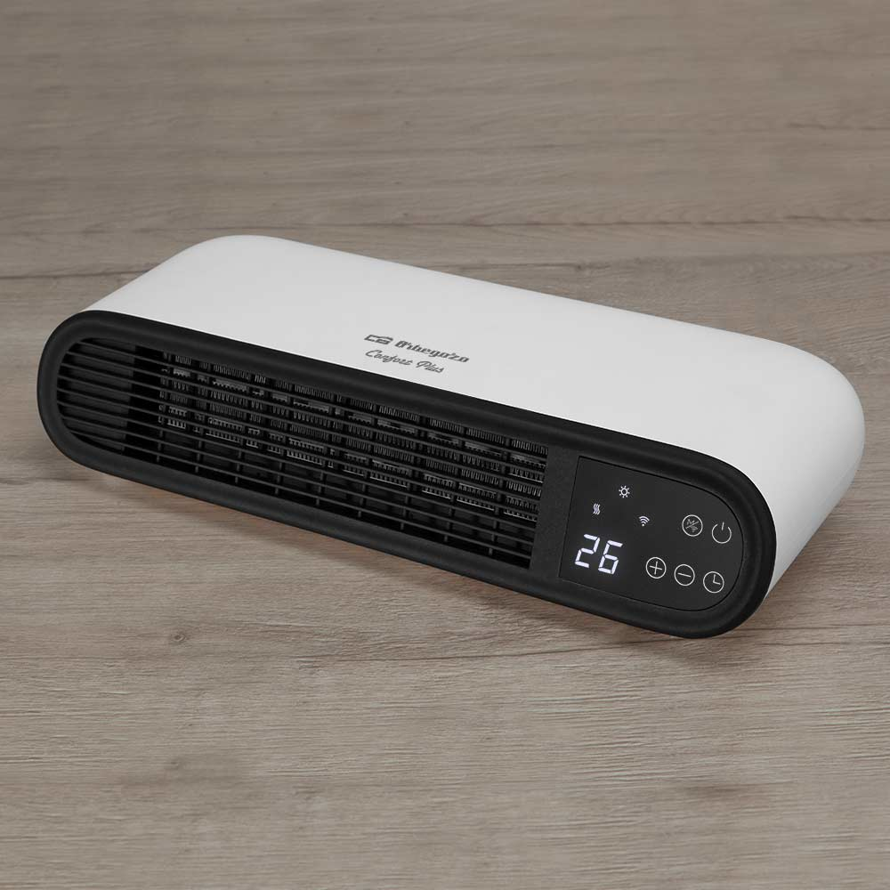 Biało-czarny grzejnik z cyfrowym wyświetlaczem. Stoi na drewnianej powierzchni.