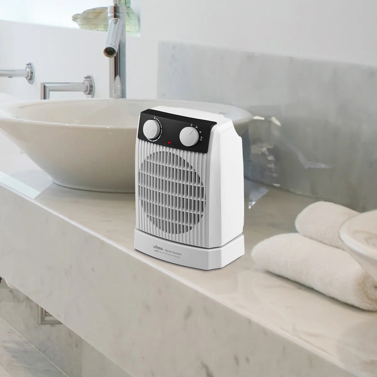 Biało-czarny grzejnik na marmurowym blacie. Widoczne dwa pokrętła i wentylator.