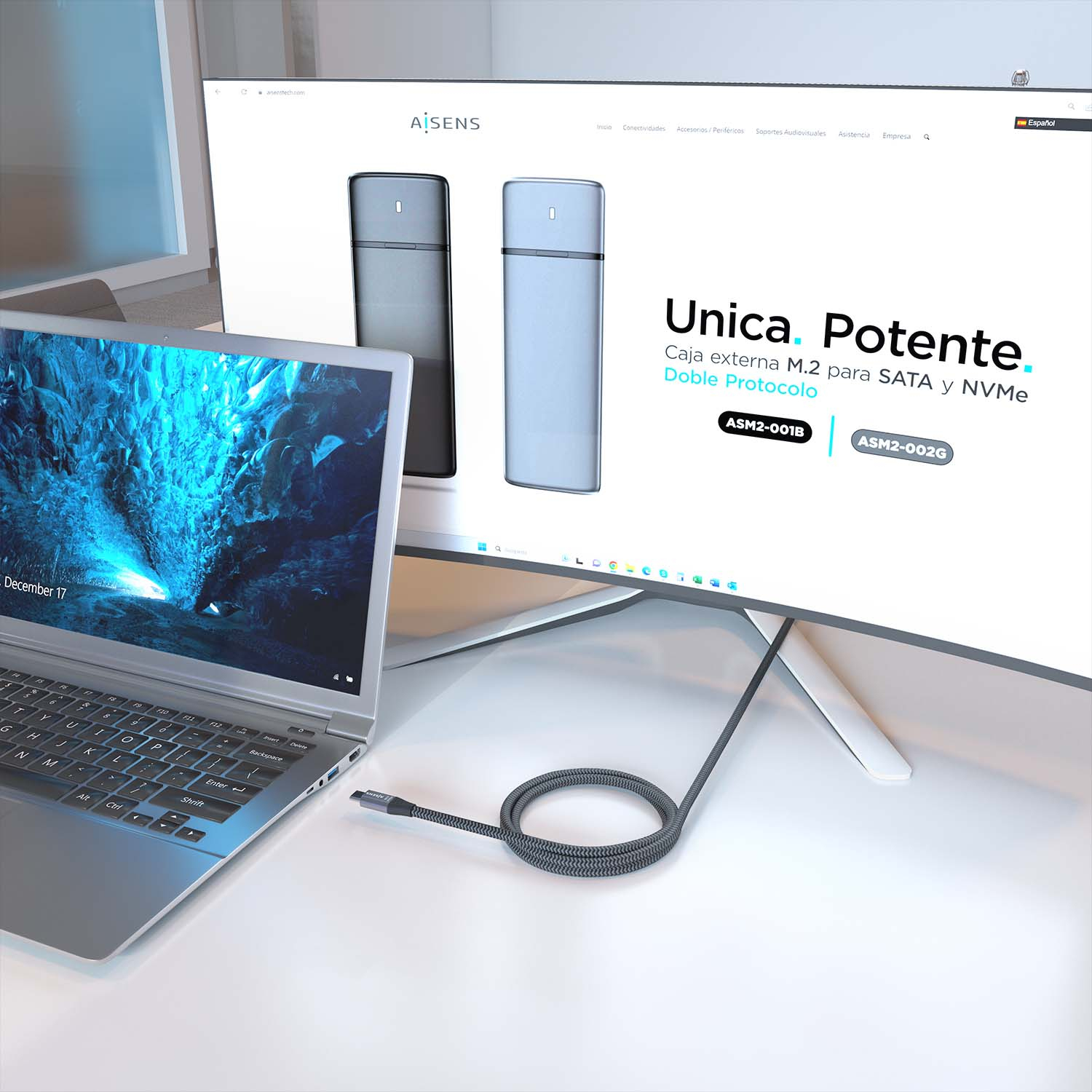 Un laptop, un monitor e un cavo su una scrivania bianca, con un sito web visualizzato sul monitor.