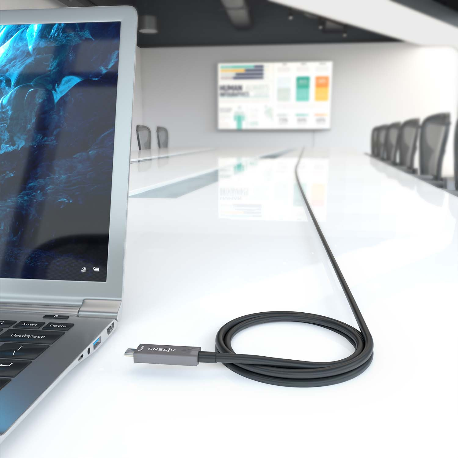 Laptop e un cavo nero collegato al tavolo.