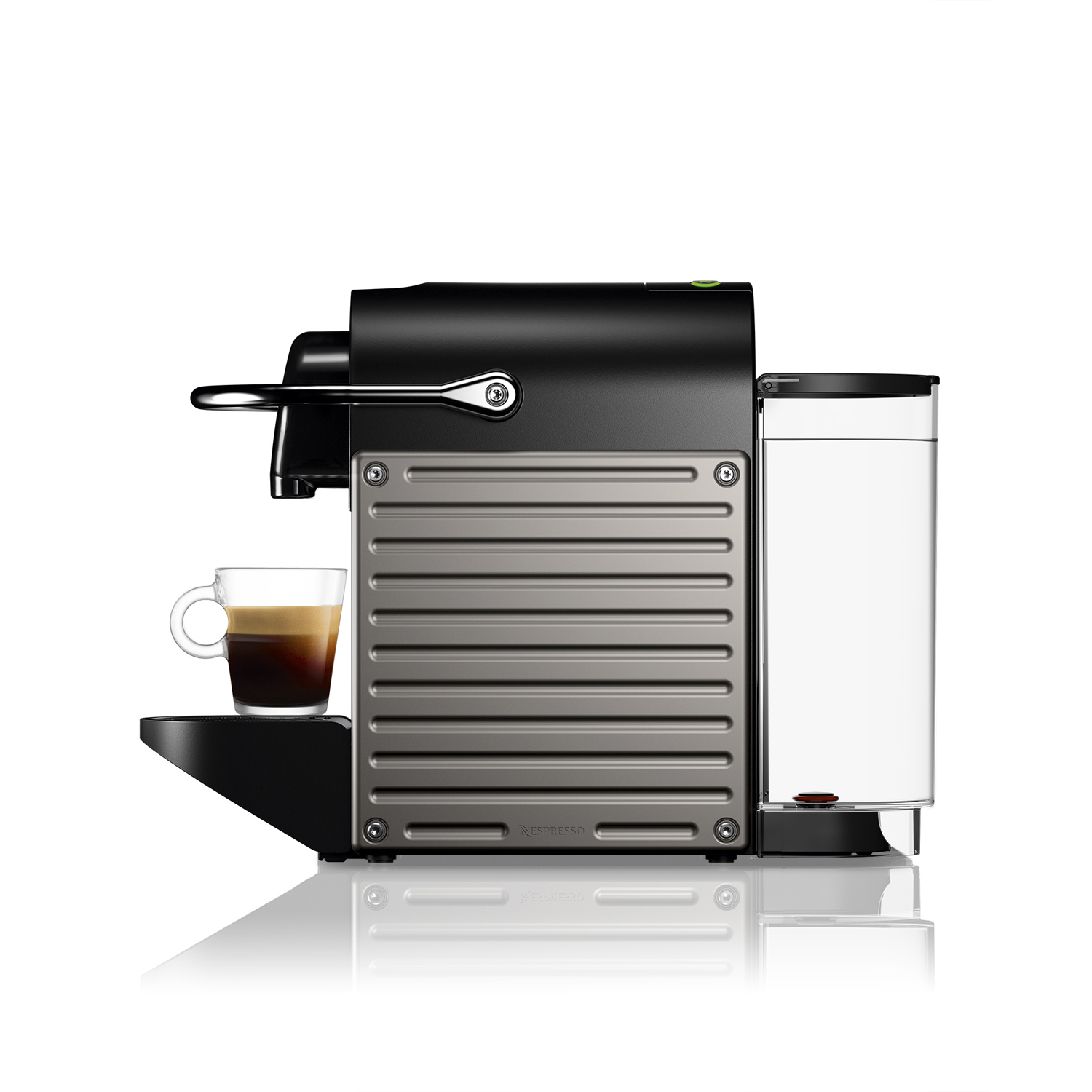 Una macchina da caffè Nespresso Pixie. Nera e grigia. Una tazza di vetro con caffè è sul vassoio.