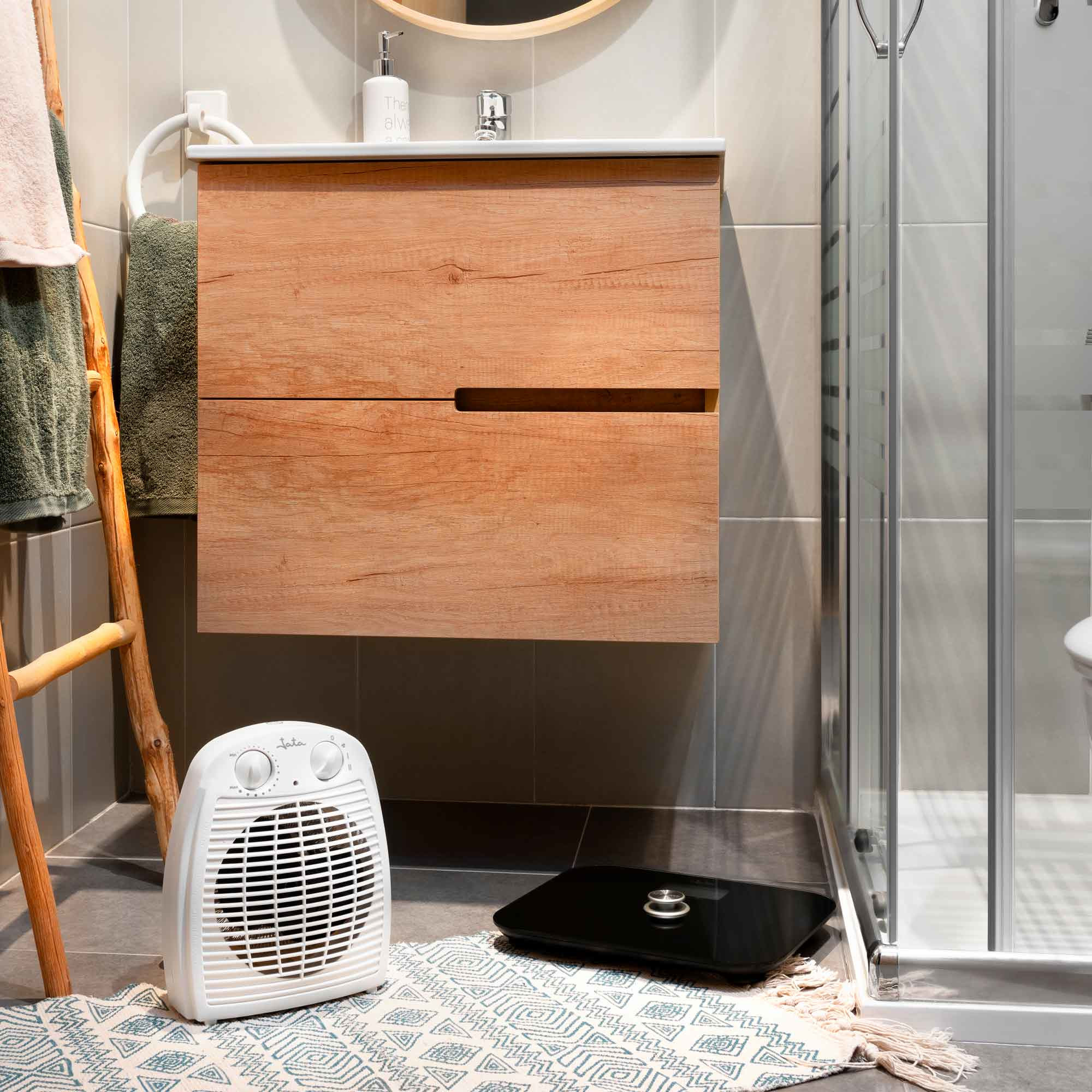 Scena łazienkowa z drewnianą szafką, umywalką, grzejnikiem, wagą i prysznicem.