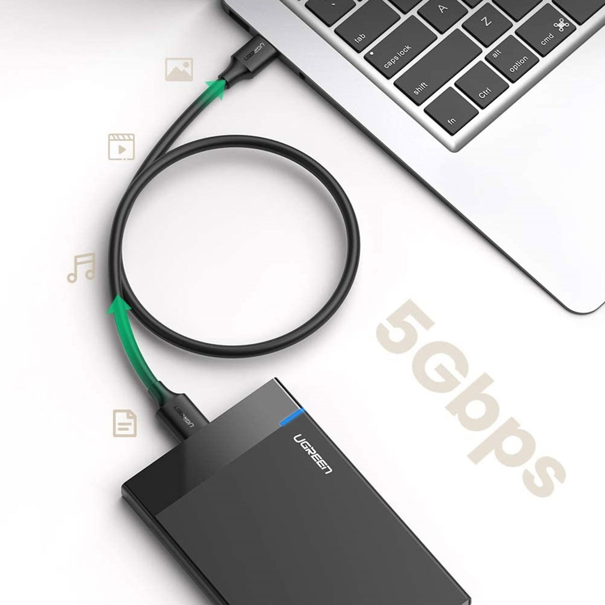 Laptop, dysk twardy i kabel USB-C z zieloną strzałką.