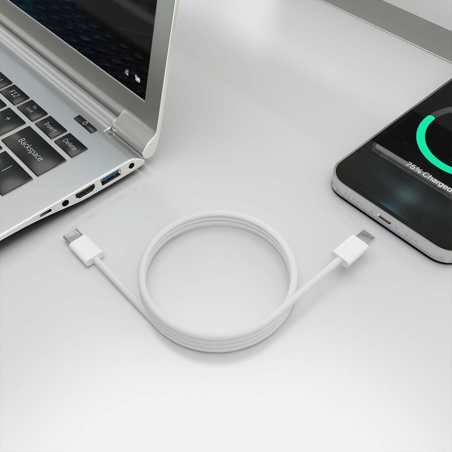 Witte USB-C-kabel tussen een laptop en een telefoon, beide op een wit oppervlak.