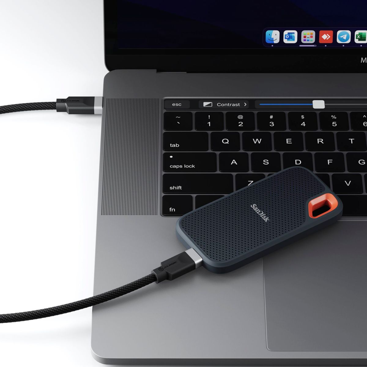 Laptop con cavo USB-C collegato a SSD Sandisk nero. Il cavo è collegato.