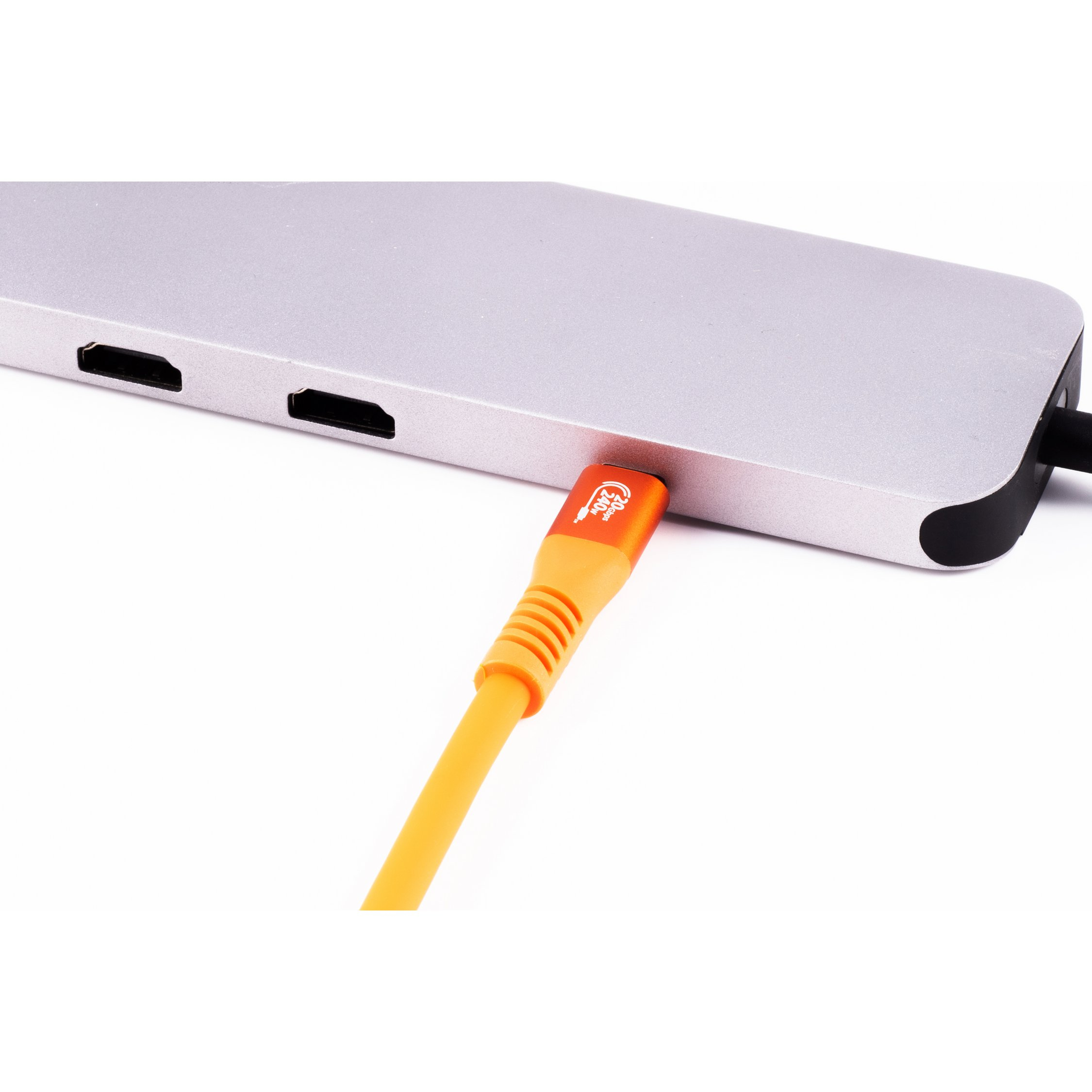 Un cavo USB arancione collegato a un hub argentato, sfondo bianco.