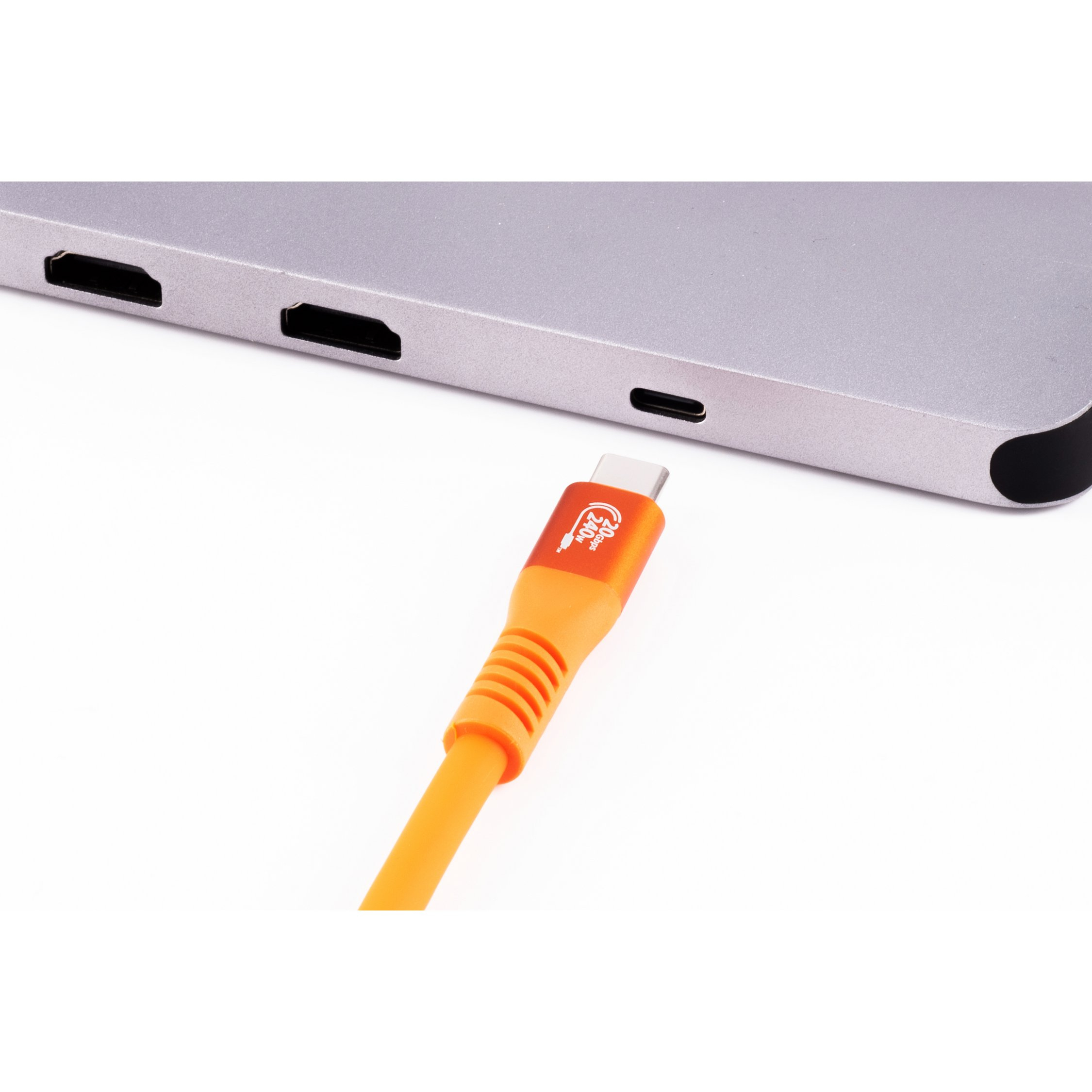 Un cavo USB-C arancione si collega a un dispositivo argentato. Lo sfondo è bianco.