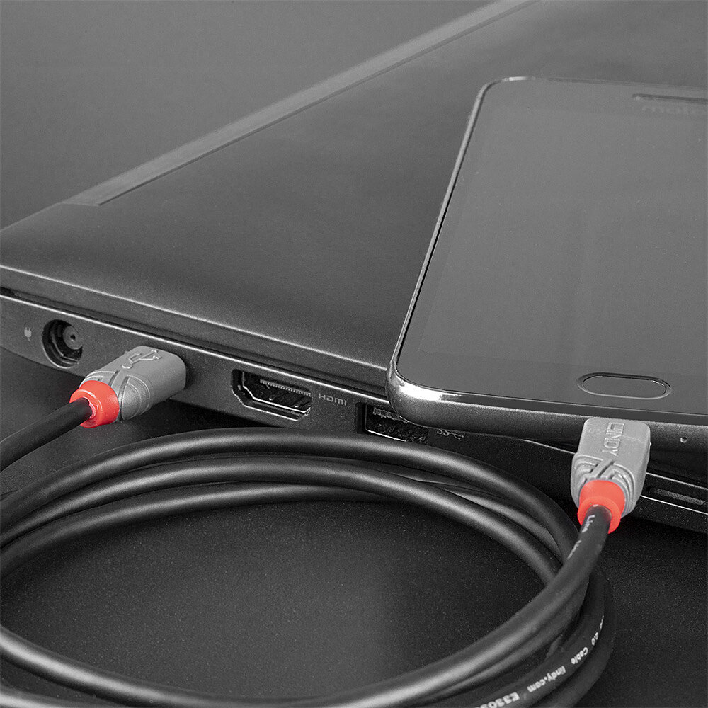 Un laptop e un telefono collegati con un cavo nero. Il cavo si collega alla porta HDMI del laptop.