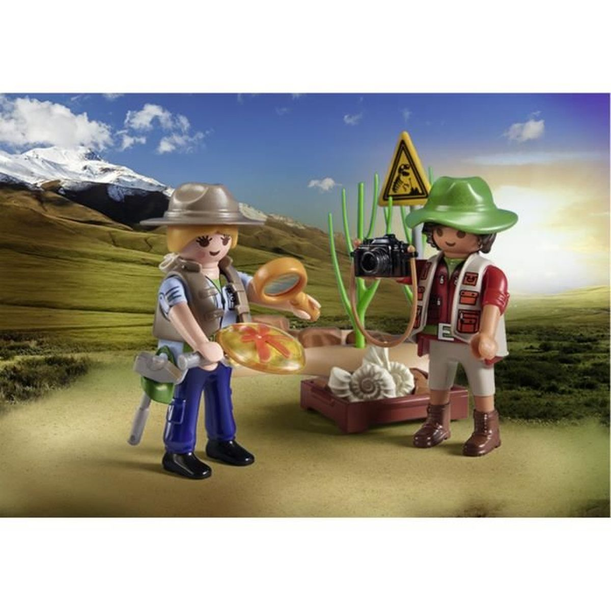 Dwie figurki Playmobil badające. Jedna trzyma lupę, druga aparat, w pobliżu wystawy muszli morskich.