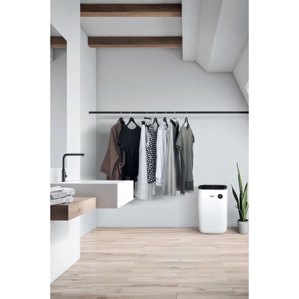 Badezimmer: weiße Wände, Kleiderstange mit Kleidung, weißer Boden.