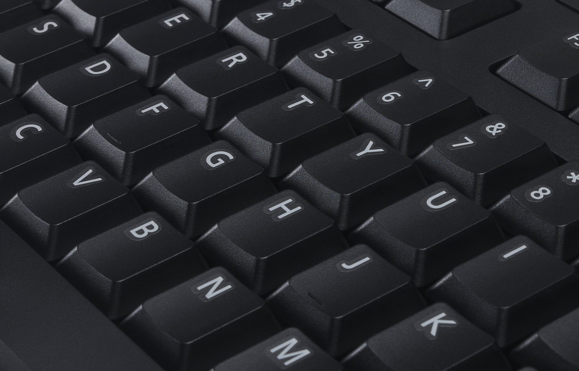 Close-up van een zwart toetsenbord. Toetsen met witte letters zijn zichtbaar. Sommige toetsen zijn afgesneden.