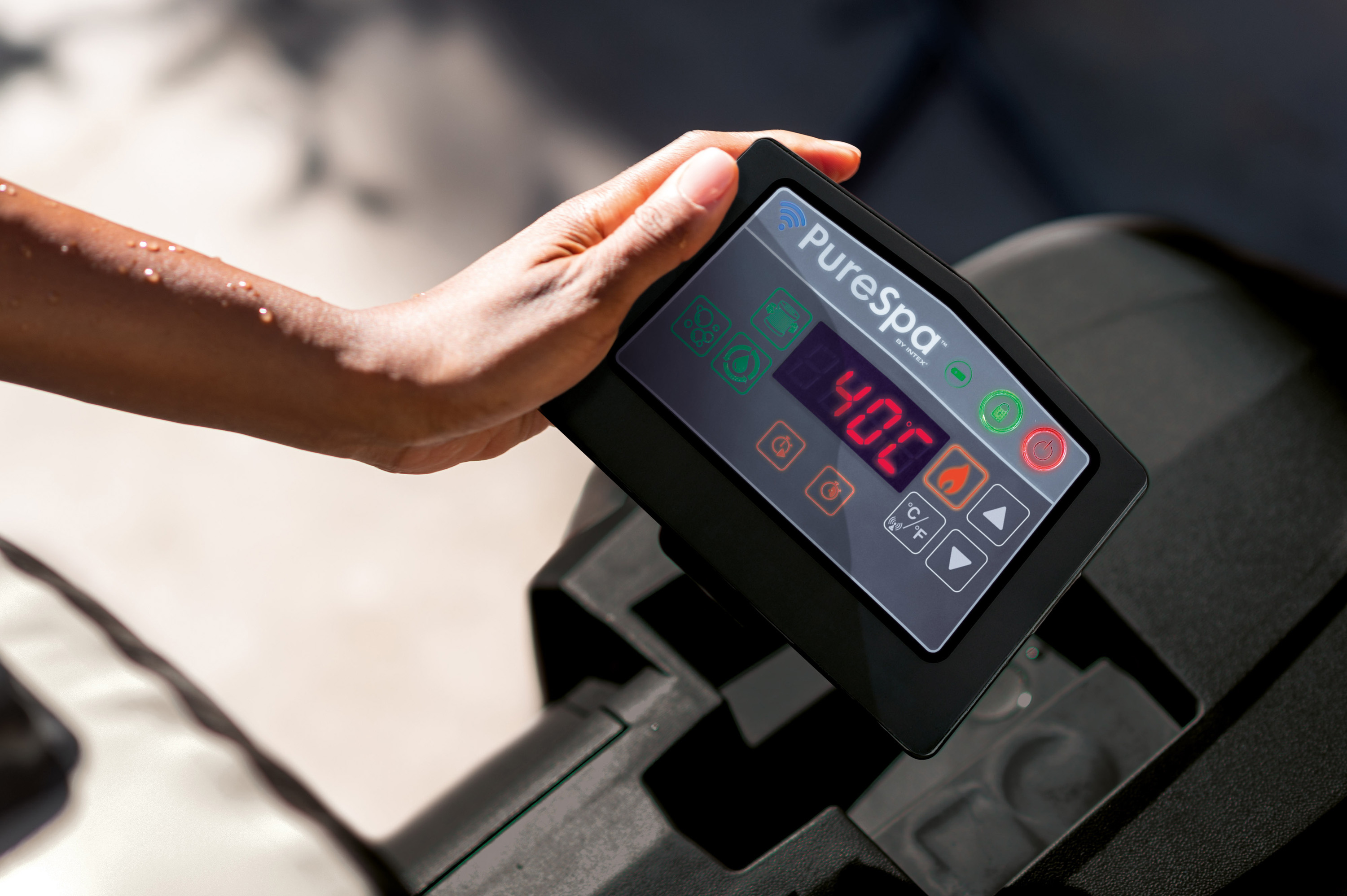 Dłoń na panelu sterowania PureSpa, z wyświetlaczem temperatury.