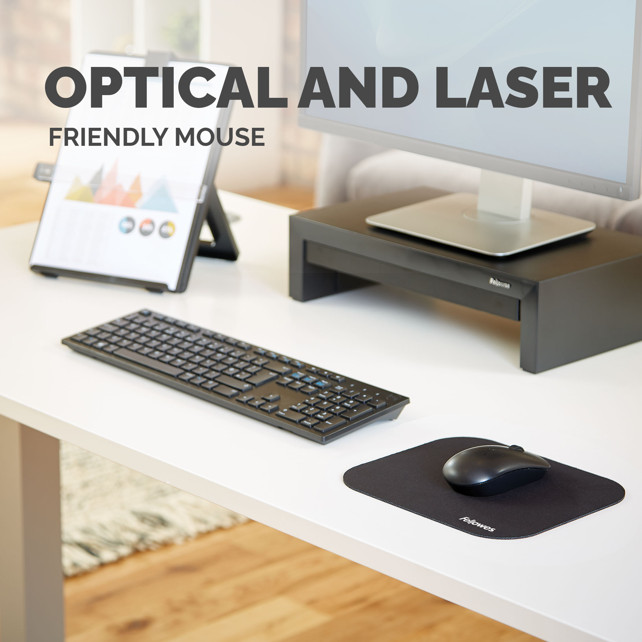 Une souris et un clavier noirs sur un bureau. Une tablette et un moniteur sont également présents.