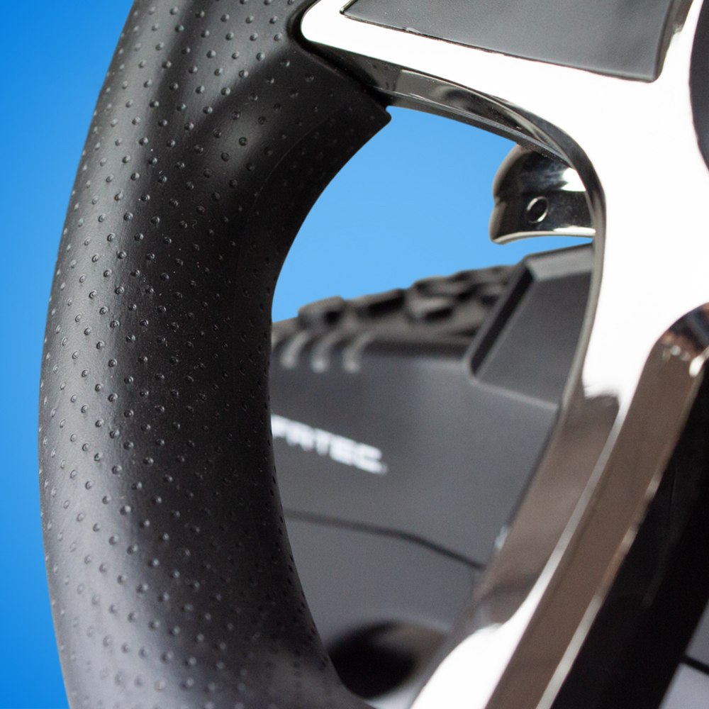 Zbliżenie kierownicy, z czarną skórą i chromem.