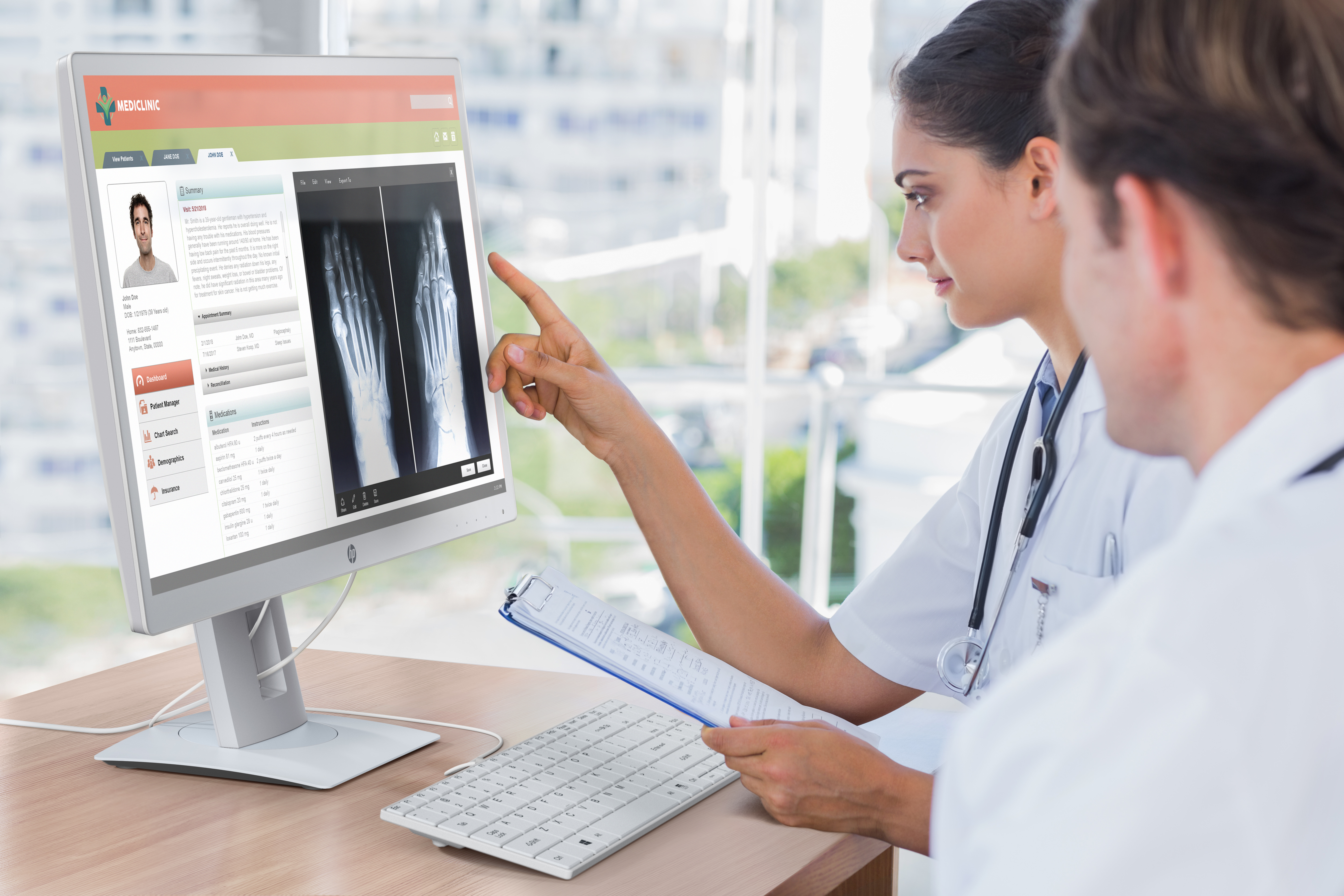 Dwóch lekarzy oglądających ekran komputera z obrazem medycznym i danymi pacjenta.