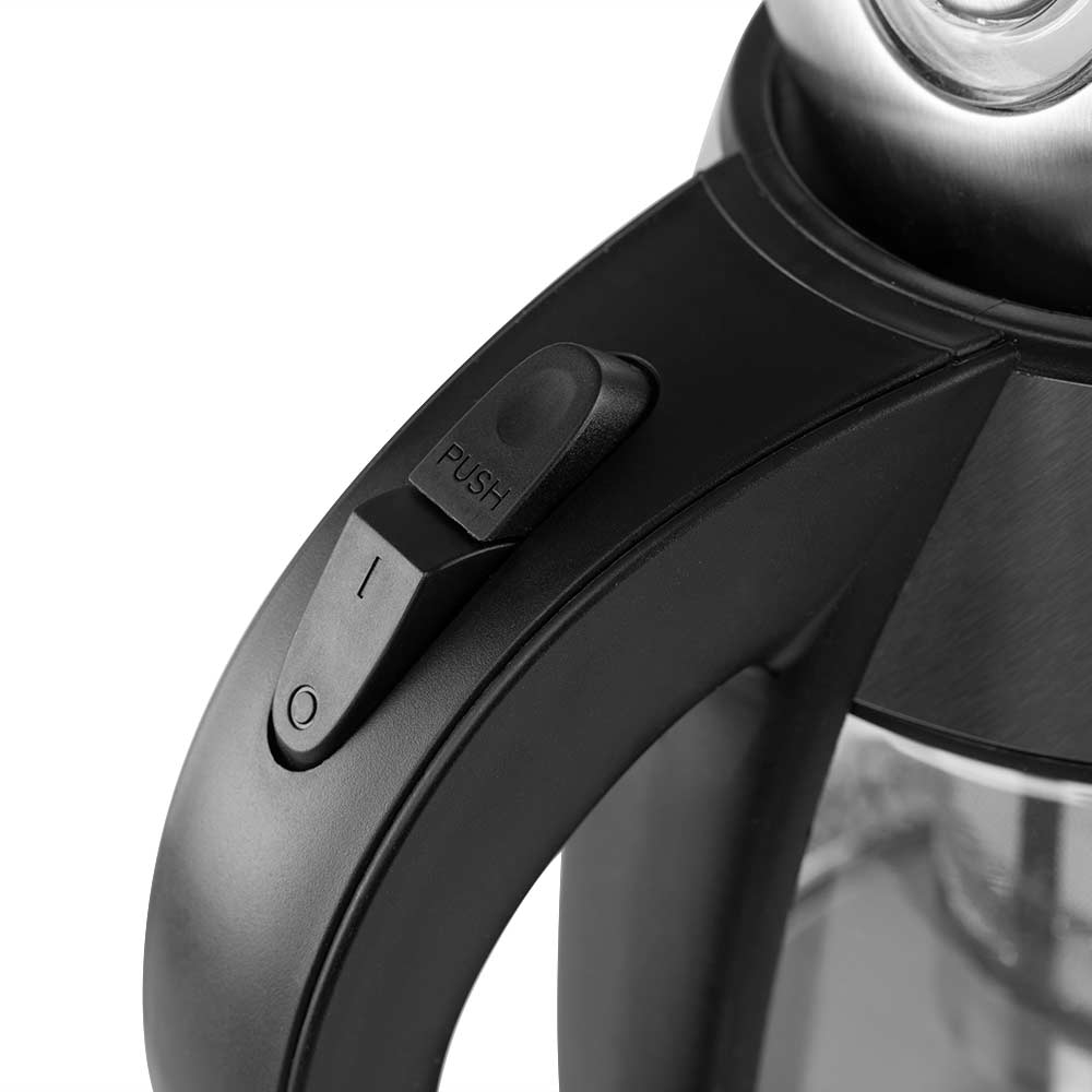 Zbliżenie czarnego uchwytu czajnika z przyciskiem 'PUSH' i wskaźnikiem zasilania. Korpus ze stali nierdzewnej.