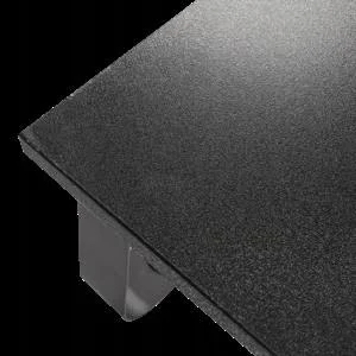 Róg czarnego stojaka na monitor z ciemną powierzchnią. Czarne tło.