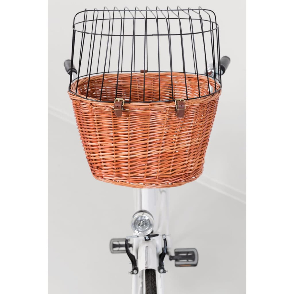 Wiklinowy kosz rowerowy z metalową klatką, zamontowany na białym rowerze.