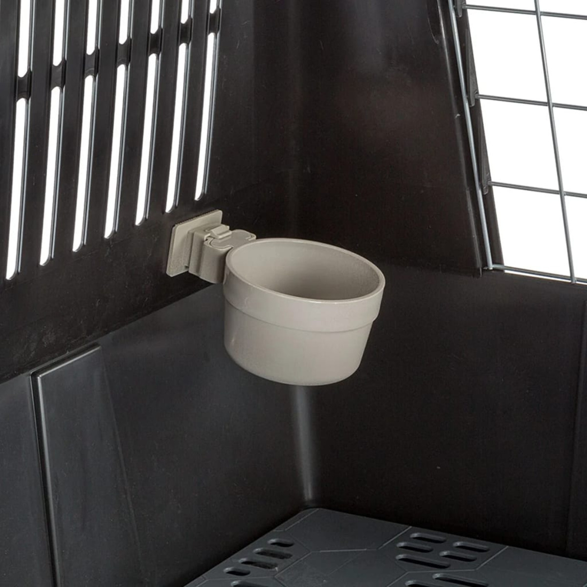 Czarny transporter dla zwierząt z szarą miską zamontowaną wewnątrz.