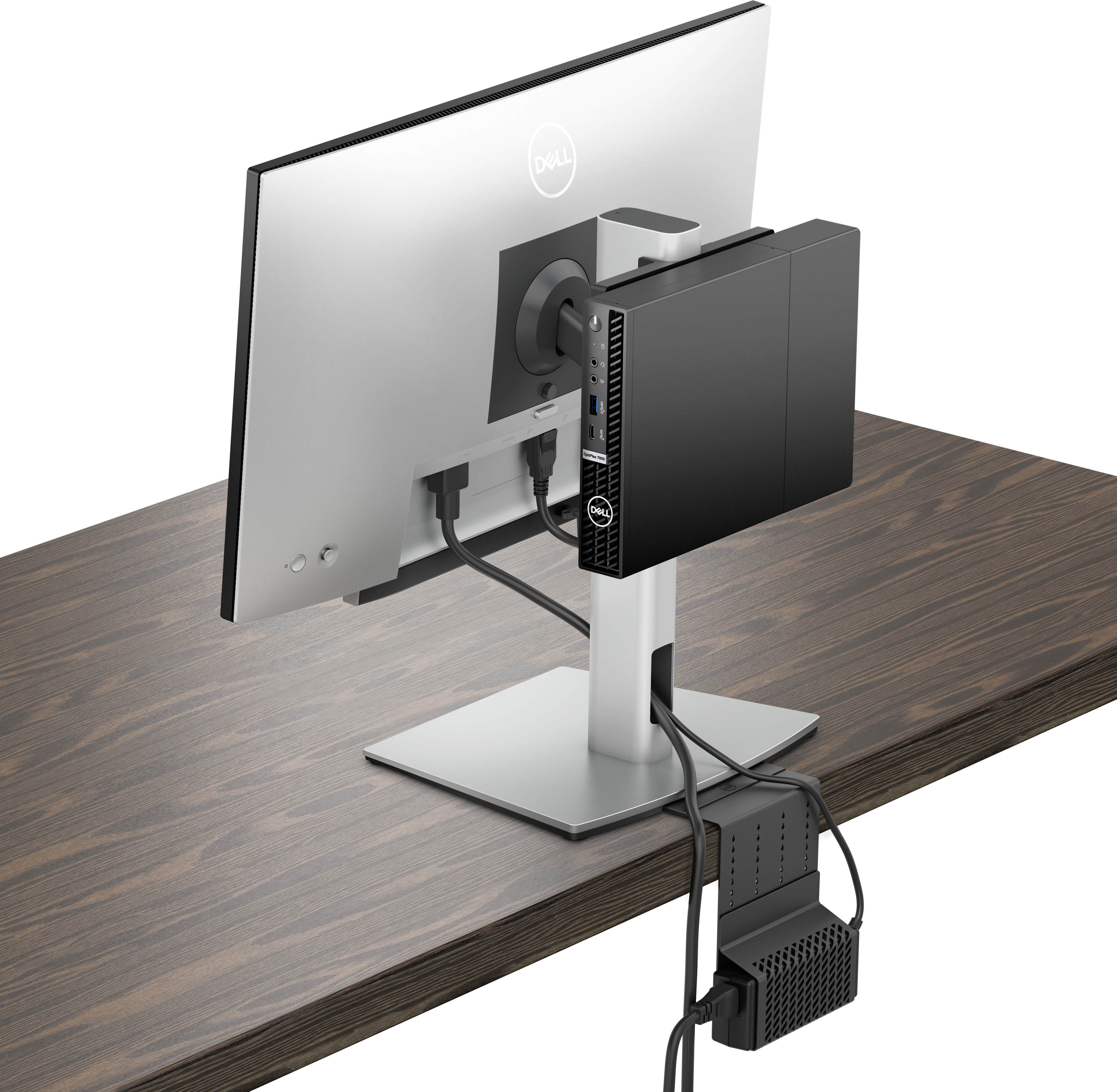 Configuration d'ordinateur Dell : Moniteur, mini-PC monté derrière et bloc d'alimentation sur un bureau en bois.