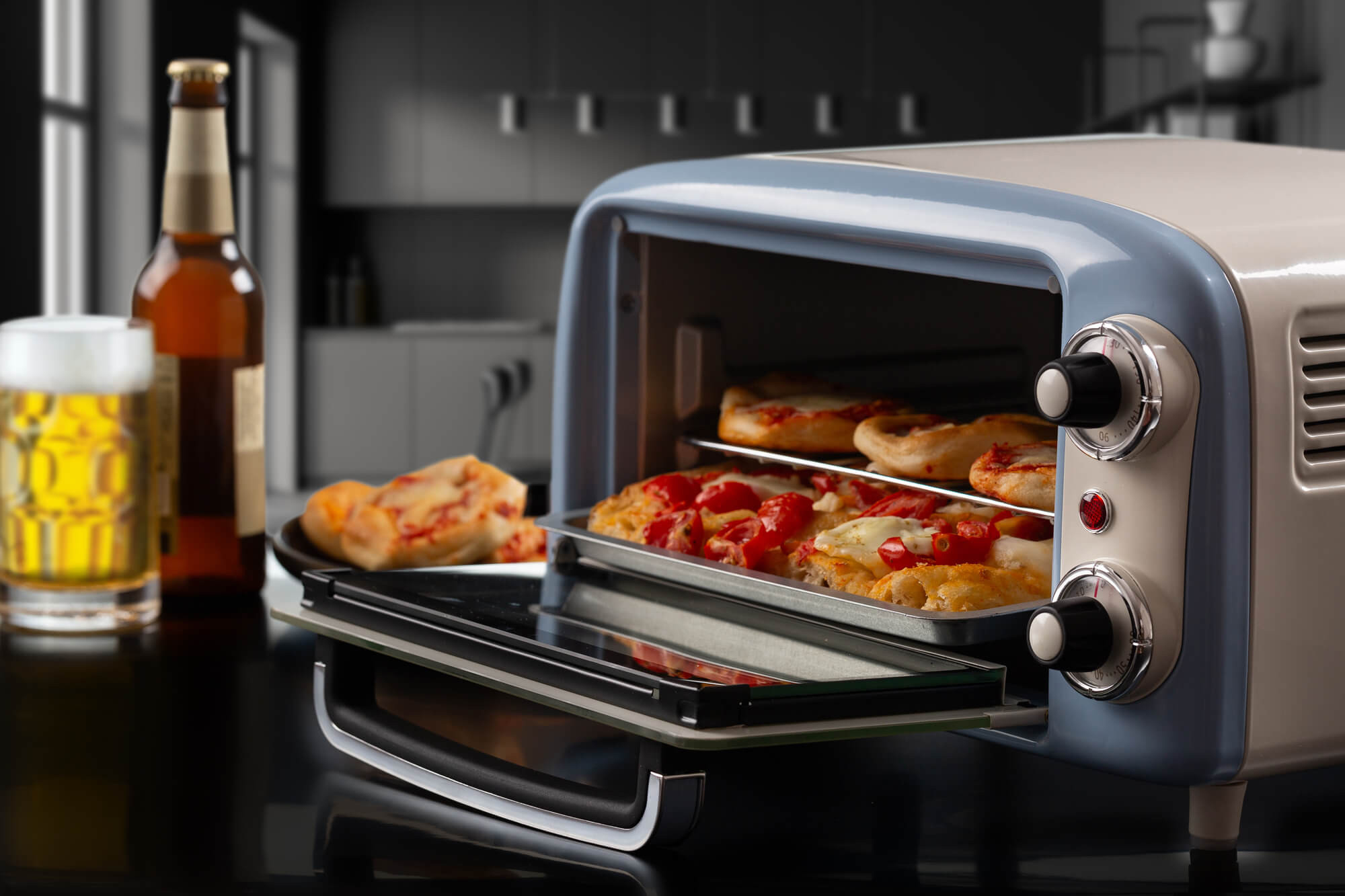 Pizza w piekarniku w stylu retro, z piwem i szklanką w tle.